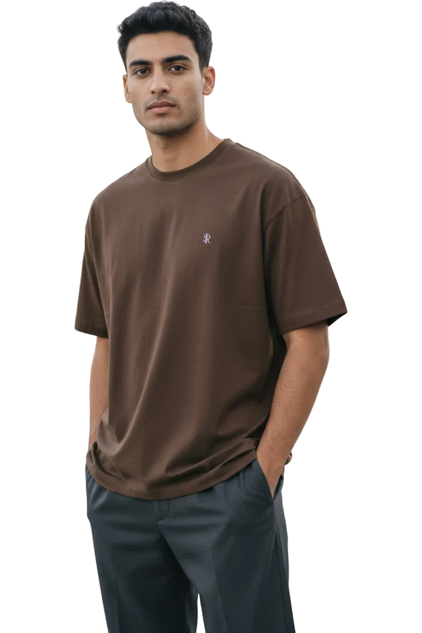 Dark brown relaxed-fit men's T-shirt with a crew neck and a small embroidered initial logo on the left chest.