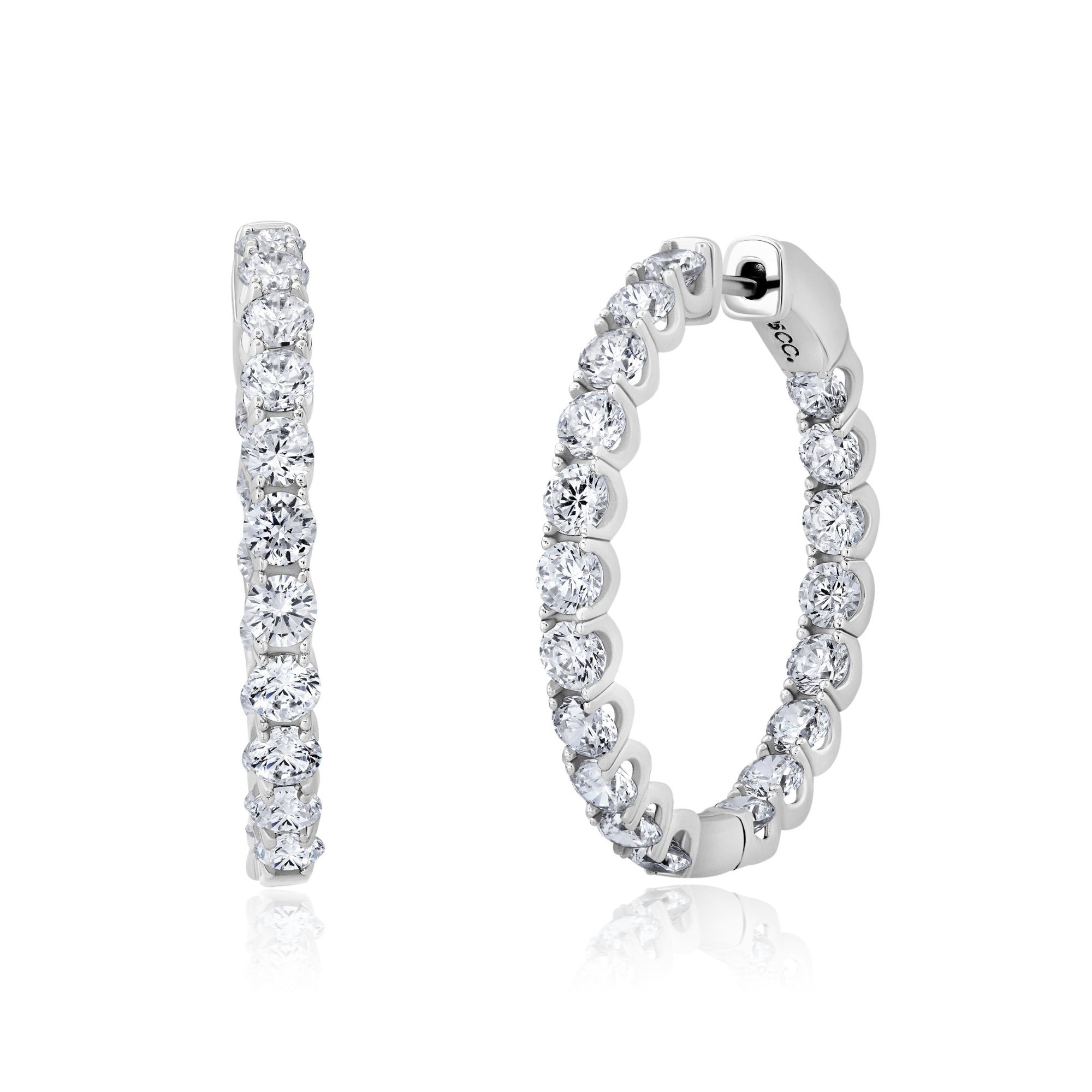 Pair of large round hoop earrings in silver-toned metal, each adorned with clear brilliant-cut stones.