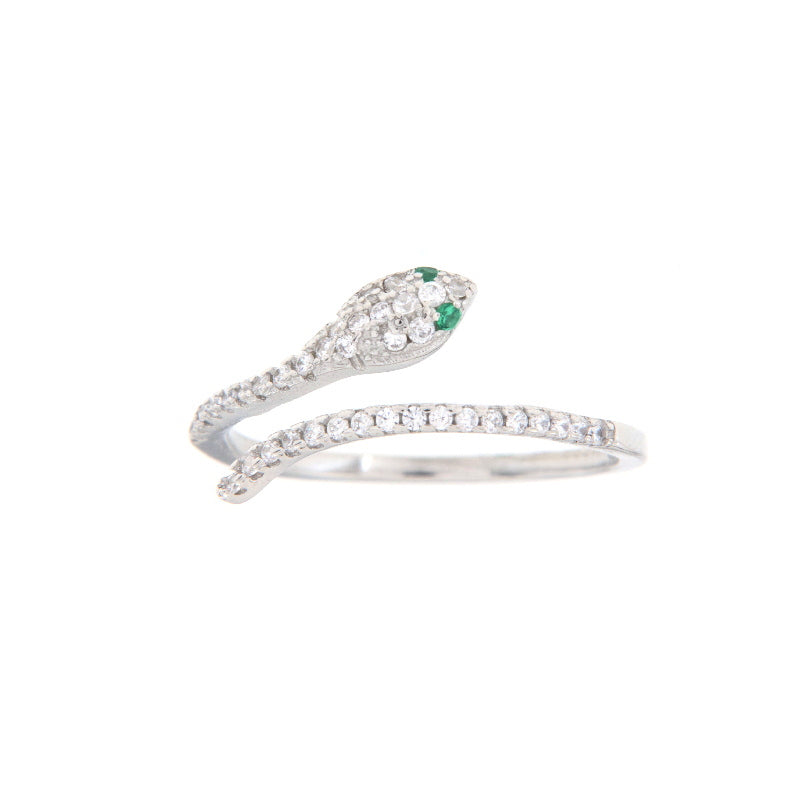 Silver-toned snake ring with pave-set clear stones and two small green stones for eyes, on a white background.