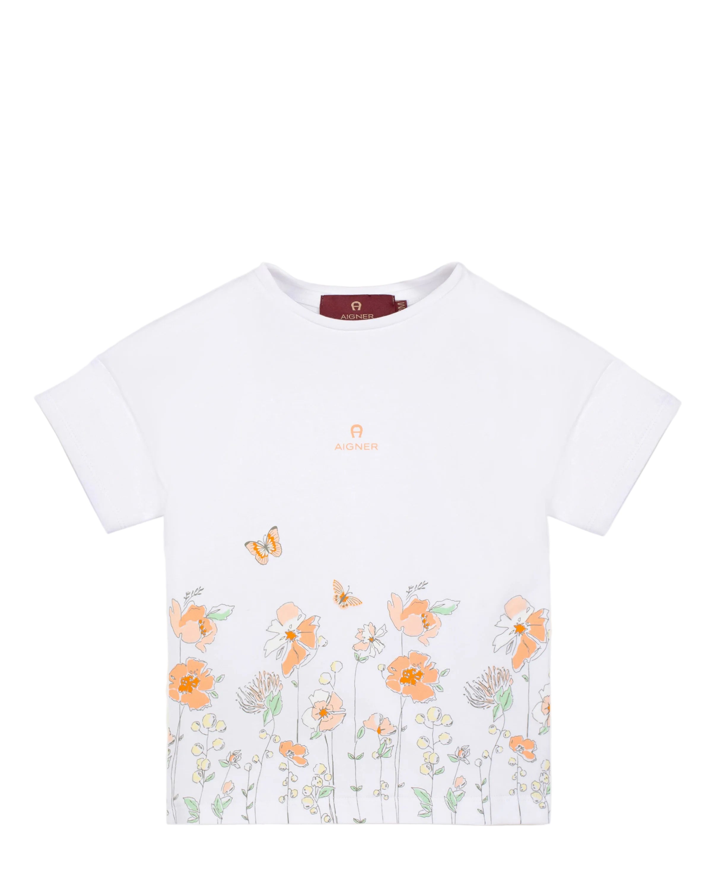 Front studio flat-lay view of the Aigner Kids girls white cotton T-shirt, highlighting the comfortable short sleeves and the vibrant orange, peach, and mint green wildflower garden border illustration.