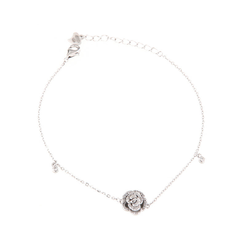 Silver-toned delicate chain bracelet with a central rose-shaped motif embellished with clear crystals, and small crystal acce