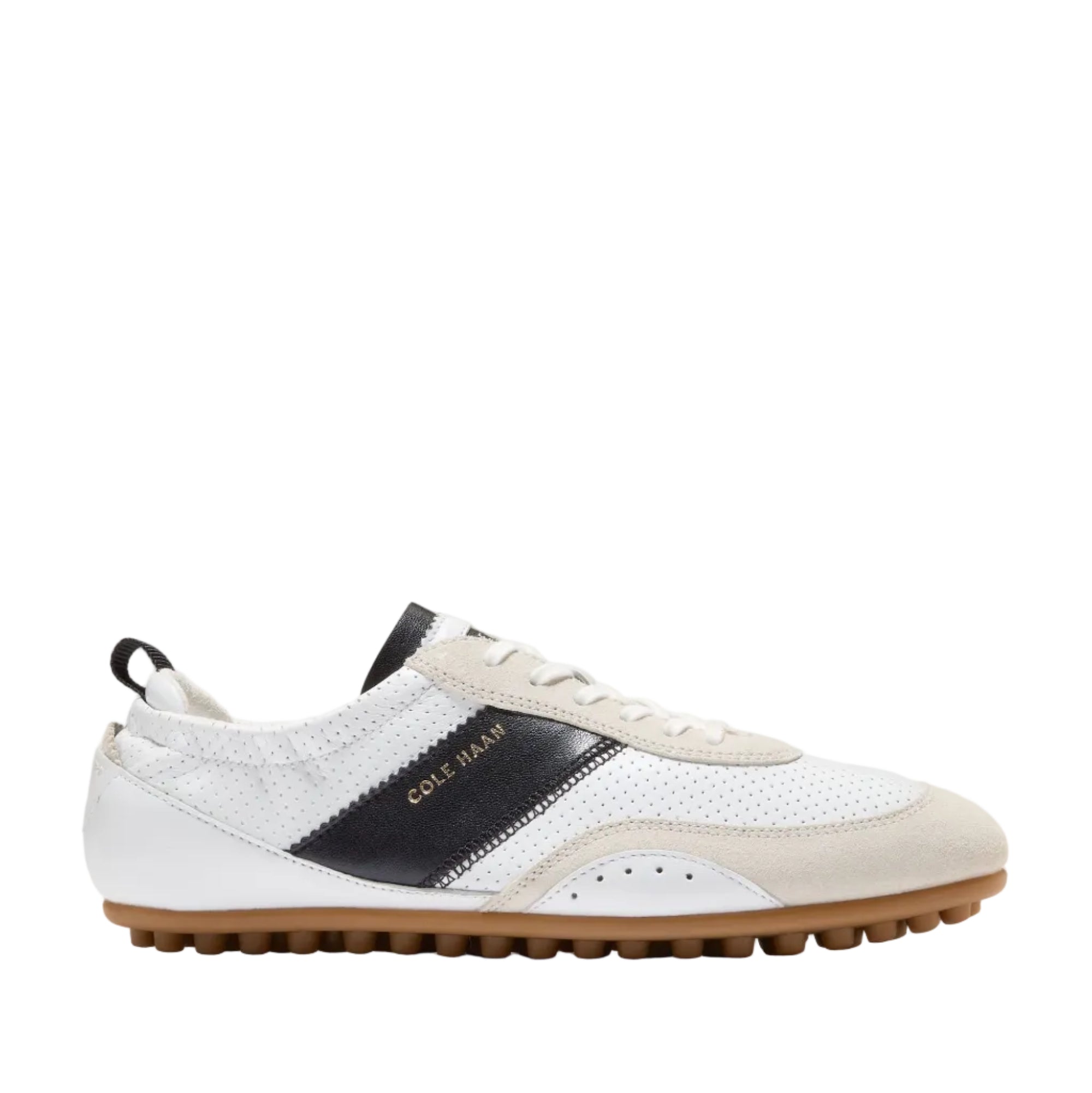 White and black Cole Haan GrandPrø Travina sneakers with a brown rubber outsole and perforated details.