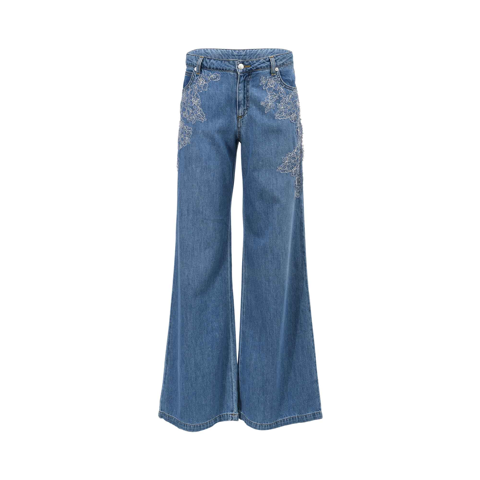 Front view of Ermanno Firenze women's wide-leg denim jeans in washed blue, detailed with white floral lace embroidery framing the upper pockets from BLUE SALON shop.