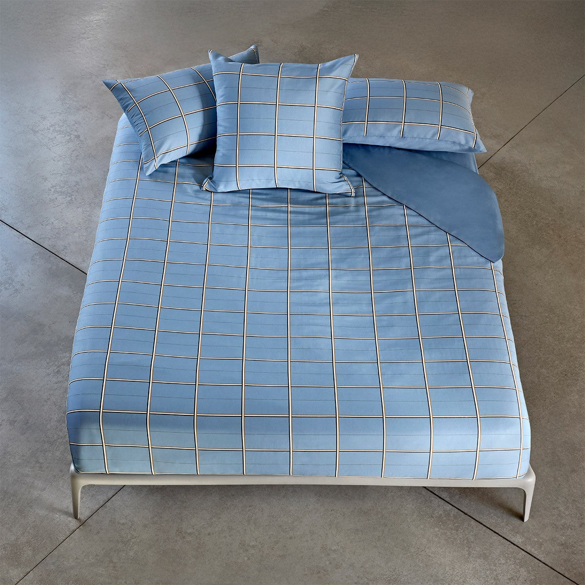 Light blue duvet cover and two pillow cases with a white and dark grid pattern.