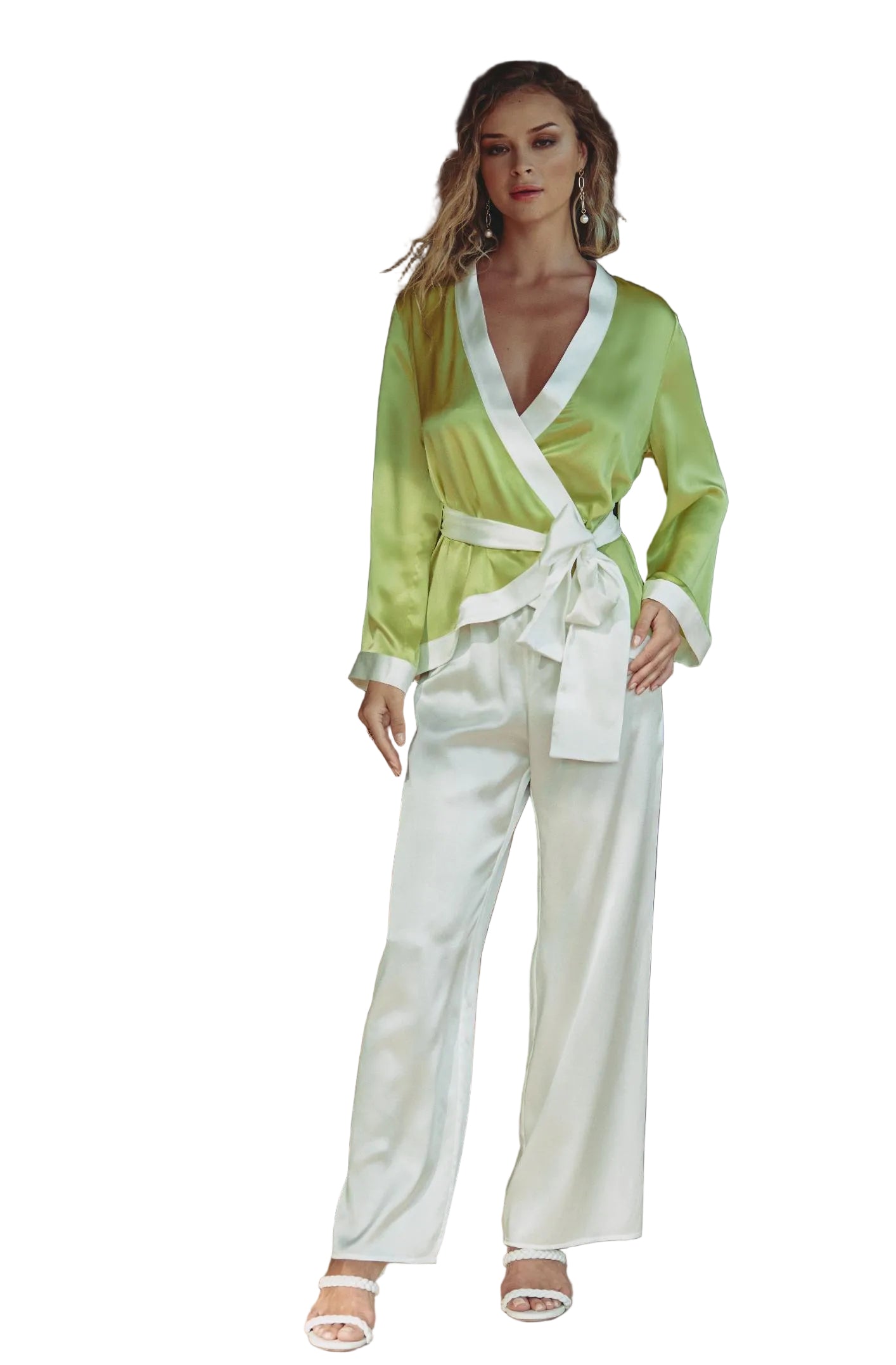 Woman in a green top and white pants standing in a living room.