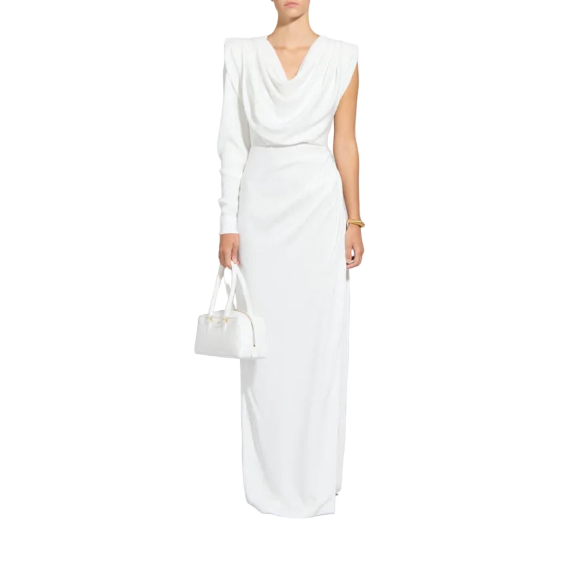 A woman modeling a long white draped dress with a deep V-neckline and sleeveless cap sleeves, holding a matching white structured handbag against a plain white background.
