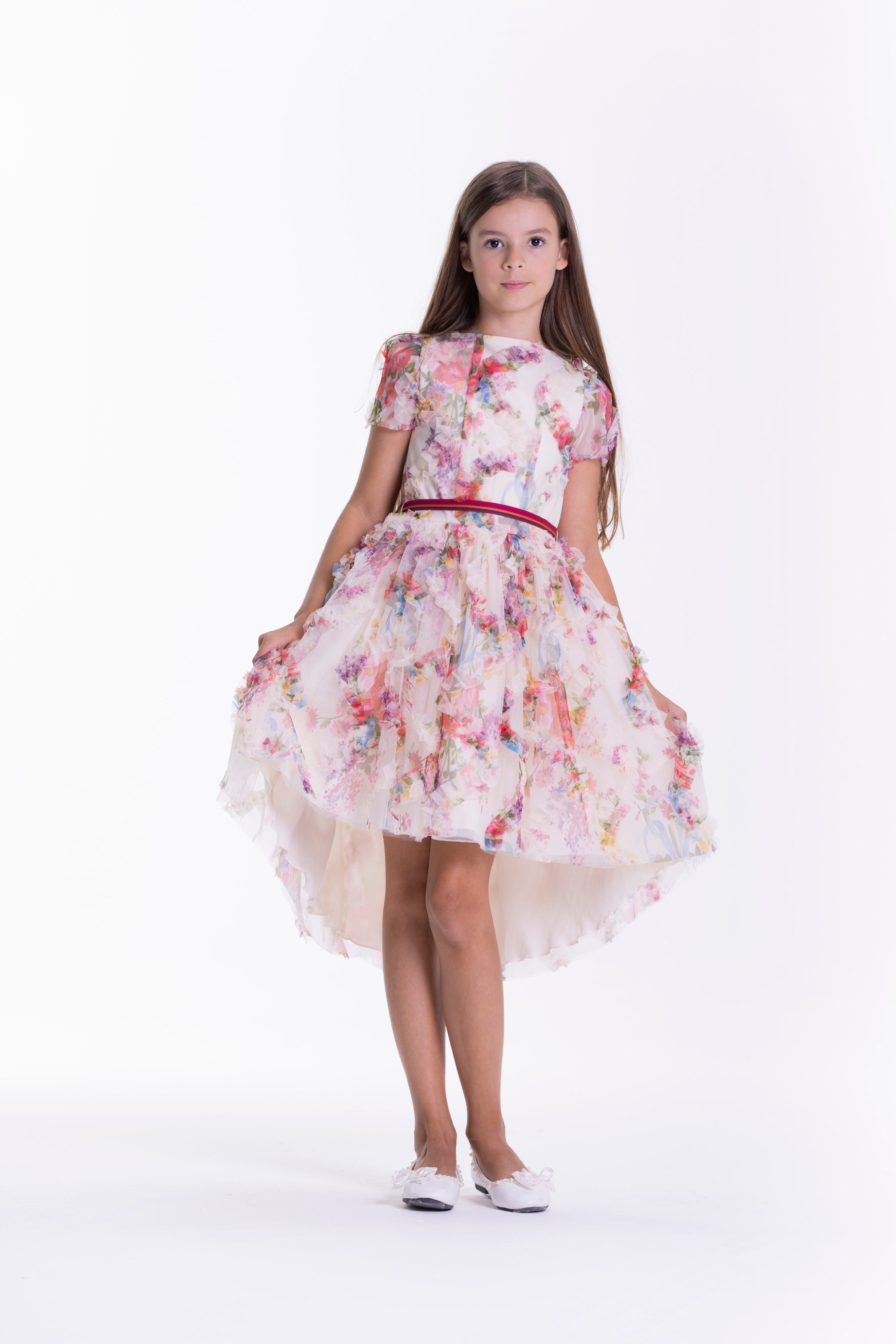 Beige floral print dress with short sleeves, round neckline, and a voluminous high-low ruffled skirt with a red belt.