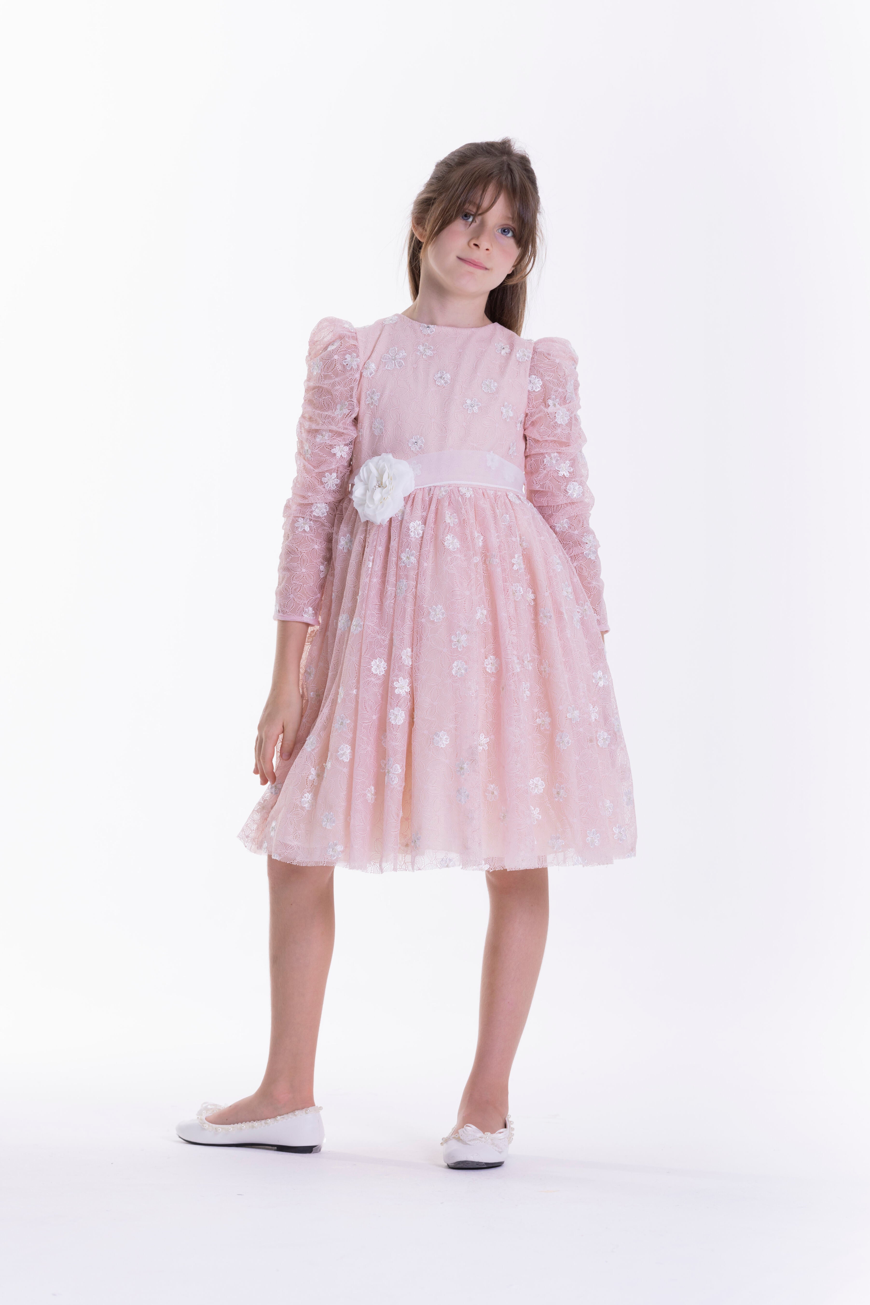 Pink long-sleeved kids' dress with silver floral embellishments, a white waist sash, and a large white flower appliqué.