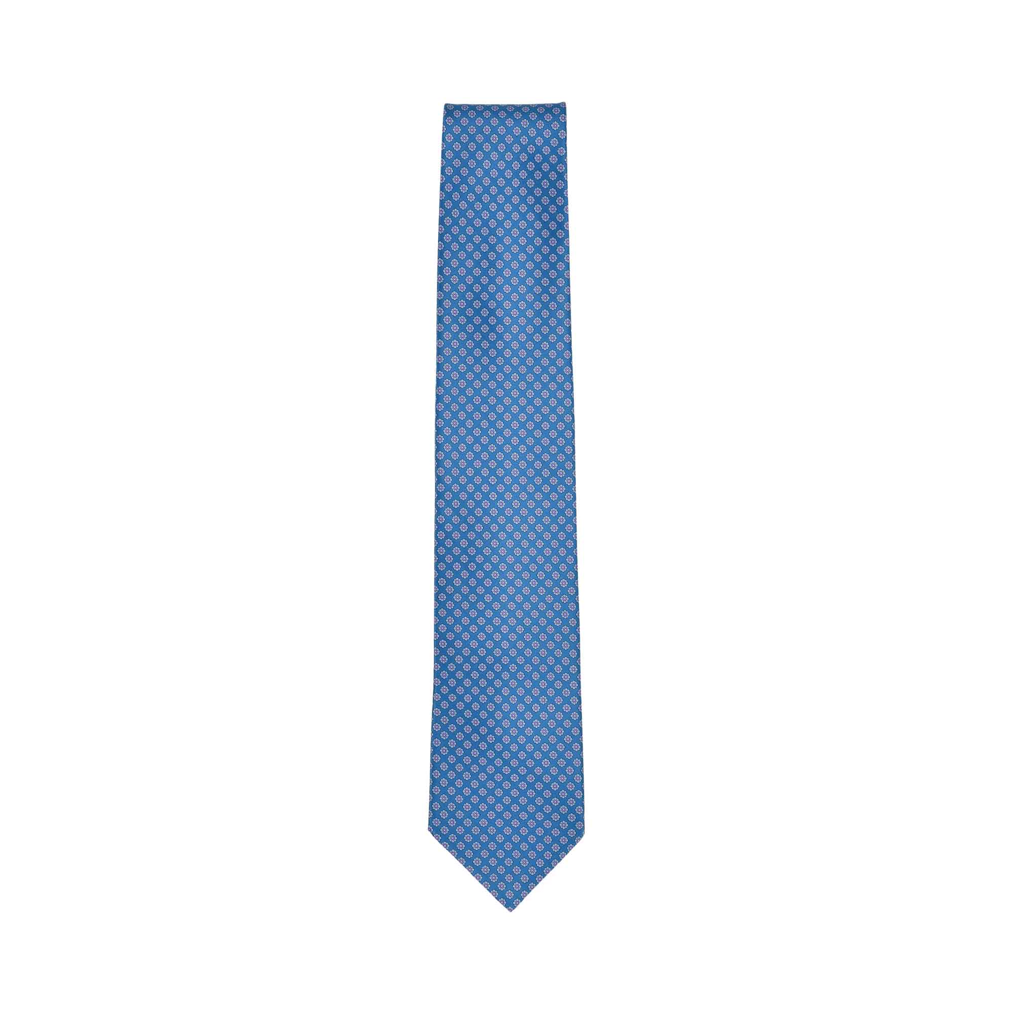 Blue silk necktie with a repeating light blue and white geometric pattern and a pointed tip.