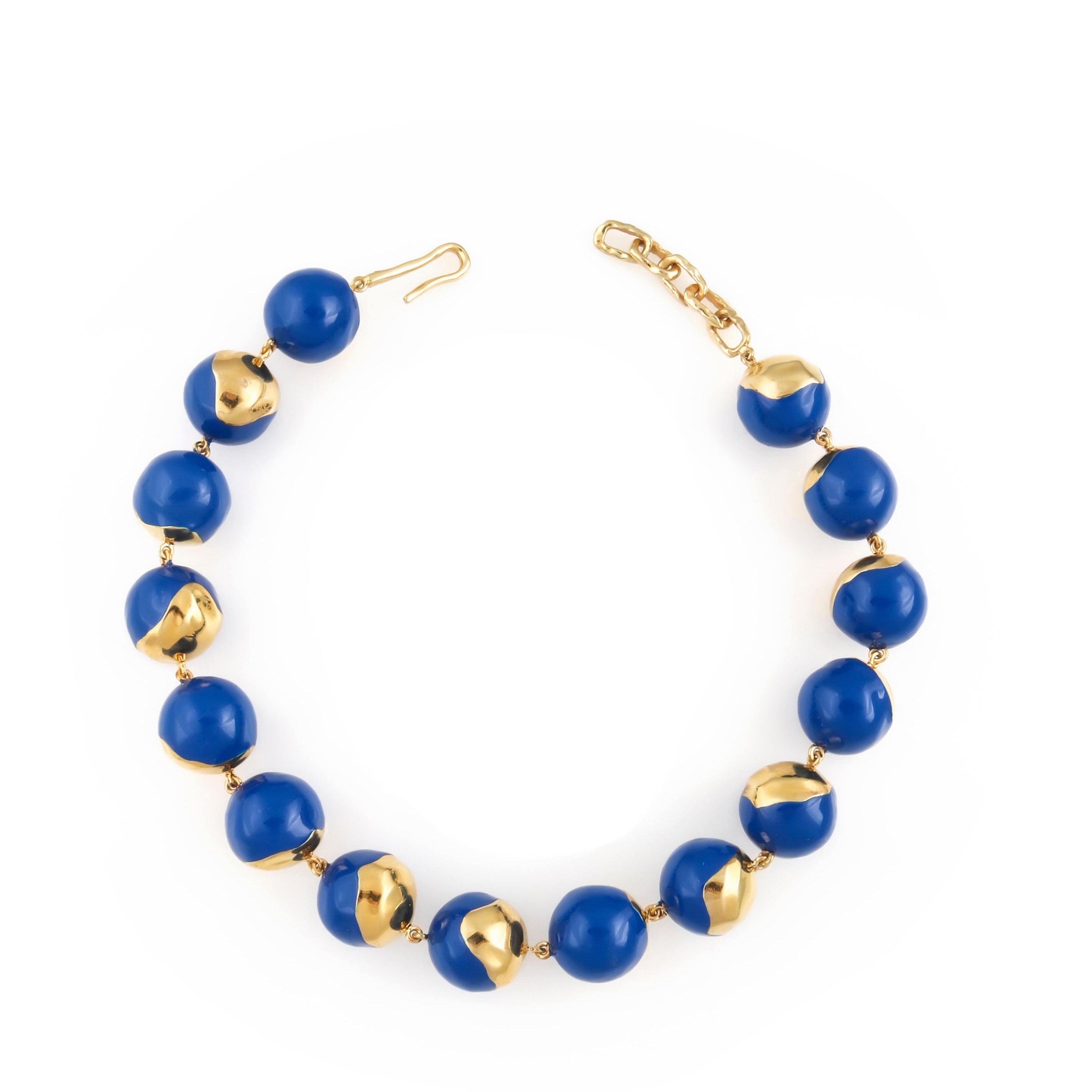 A necklace composed of royal blue enamelled spherical orbs, some featuring irregular gold-toned textured sections, with a gol