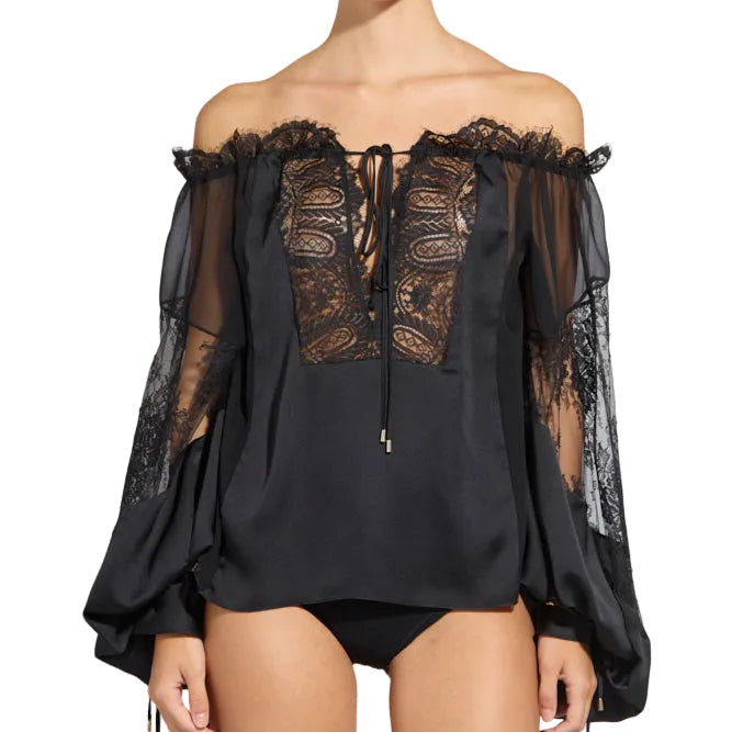 Studio shot of a model wearing a black Zuhair Murad off-the-shoulder blouse with intricate lace bodice panels and sheer balloon sleeves.