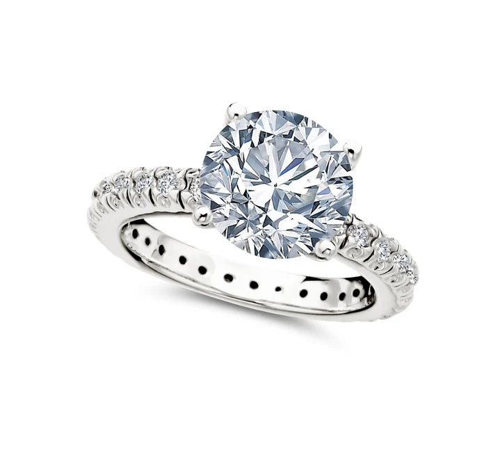 Silver-toned pavé engagement ring with a large, clear round brilliant-cut central stone and smaller clear stones on the band.