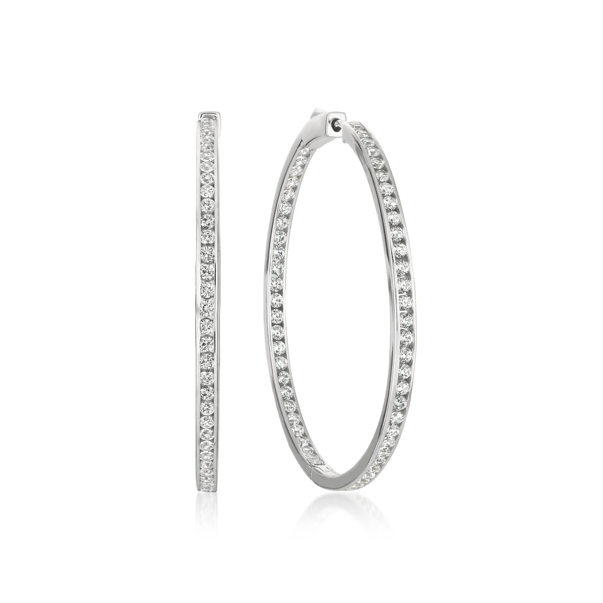 Pair of silver-toned inside-out hoop earrings with clear sparkling stones set along both inner and outer surfaces.