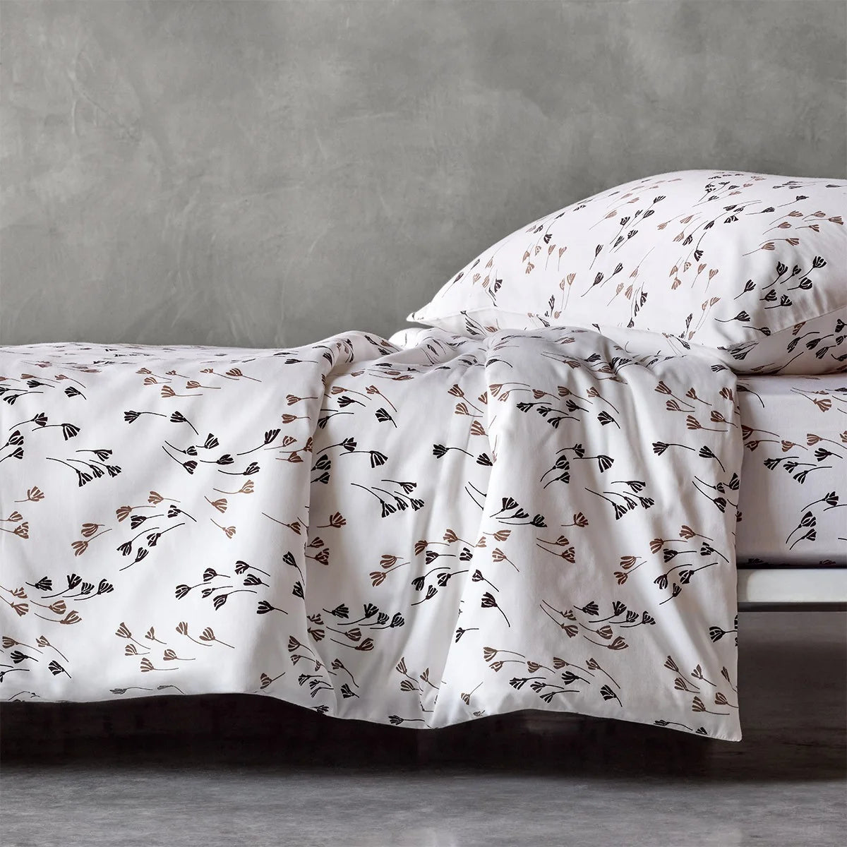 White duvet cover and pillow case set with a beige and dark brown stylised botanical pattern.
