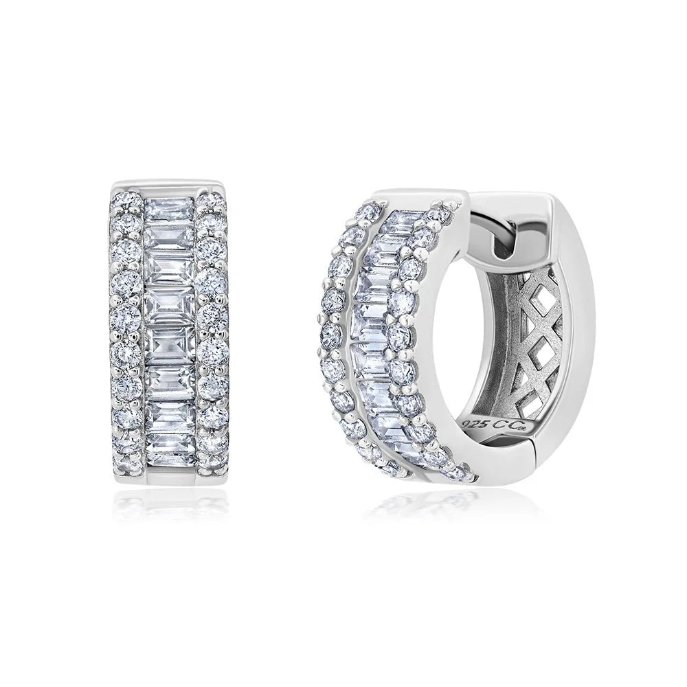 Pair of silver-toned huggie earrings, each featuring a central row of clear baguette stones flanked by two rows of clear roun