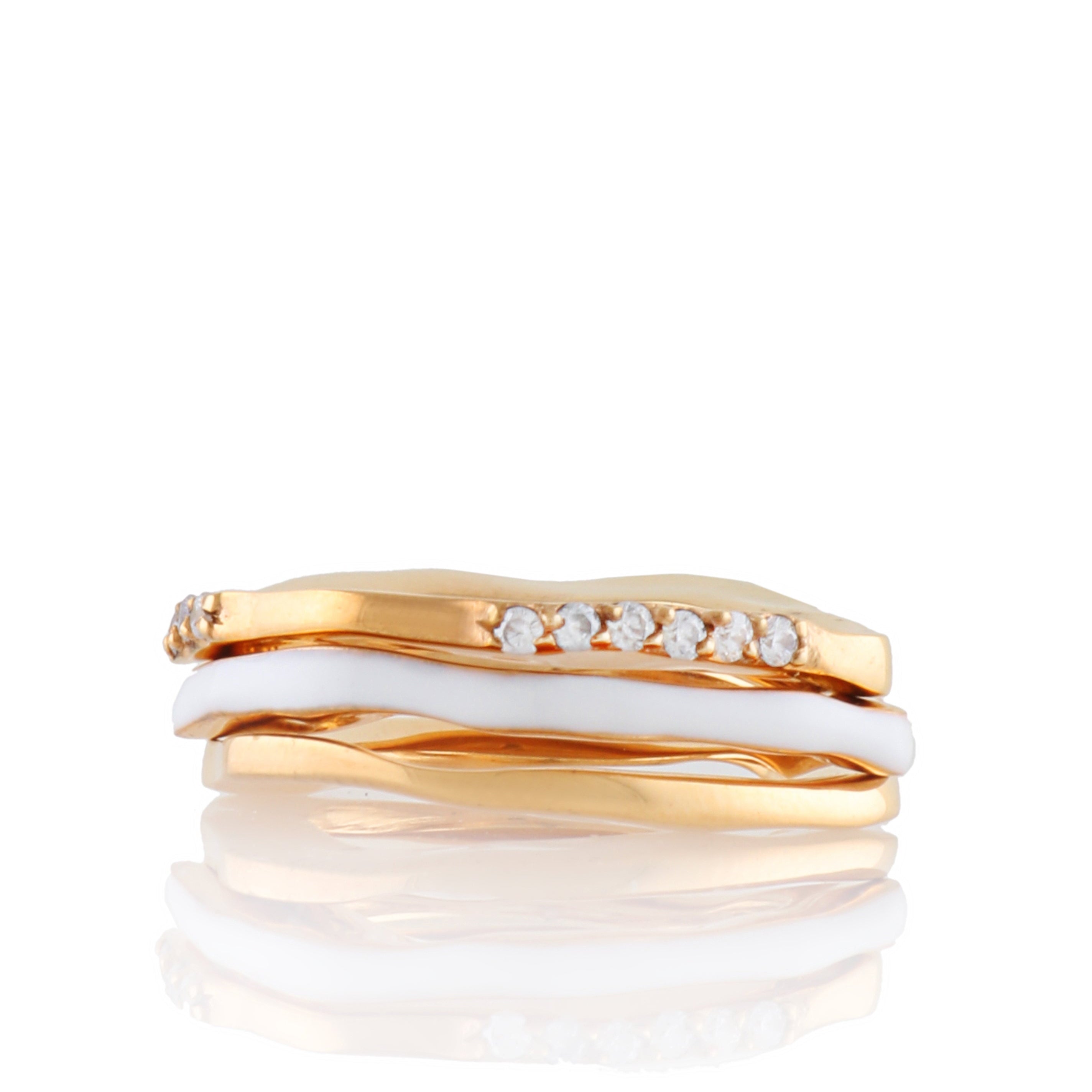 Set of three gold-toned wave rings, one with white enamel, another with a row of clear stones.