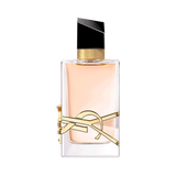 Rectangular clear glass perfume bottle with pale liquid, gold-toned YSL logo, textured gold collar, and an angled black cap.
