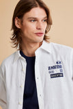 Optic white linen-blend shirt with collar and button front. Right chest has blue 'LA MARTINA' logo, '03', 'Bs As', 'ARGENTINA
