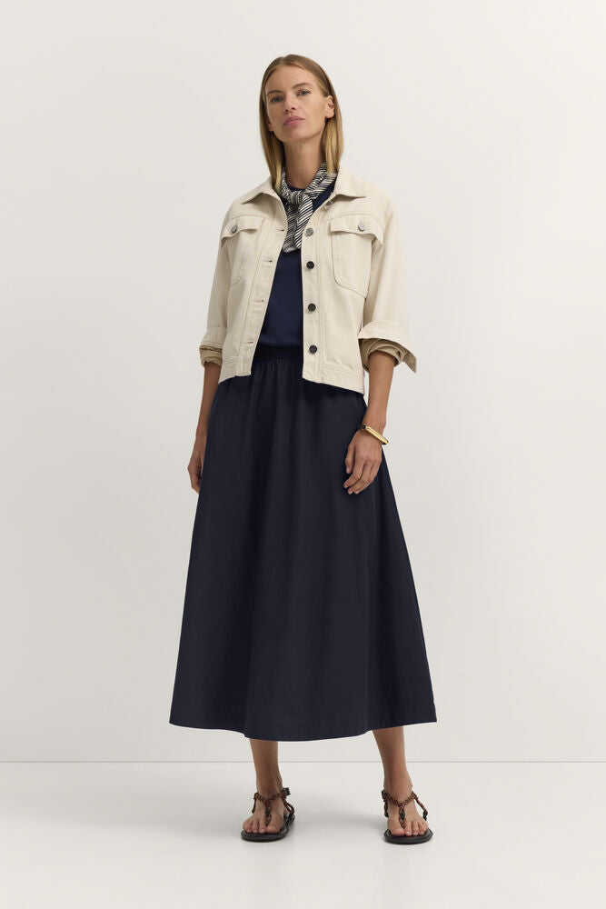 Navy blue long skirt with an elasticated waist and a flowing, A-line silhouette, reaching mid-calf.