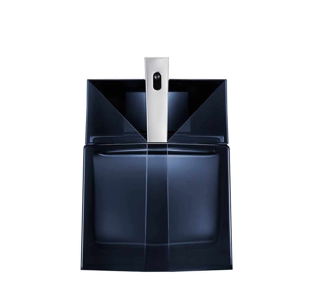Dark blue translucent fragrance bottle with a rectangular base and sharply angled shoulders, featuring a central silver-toned