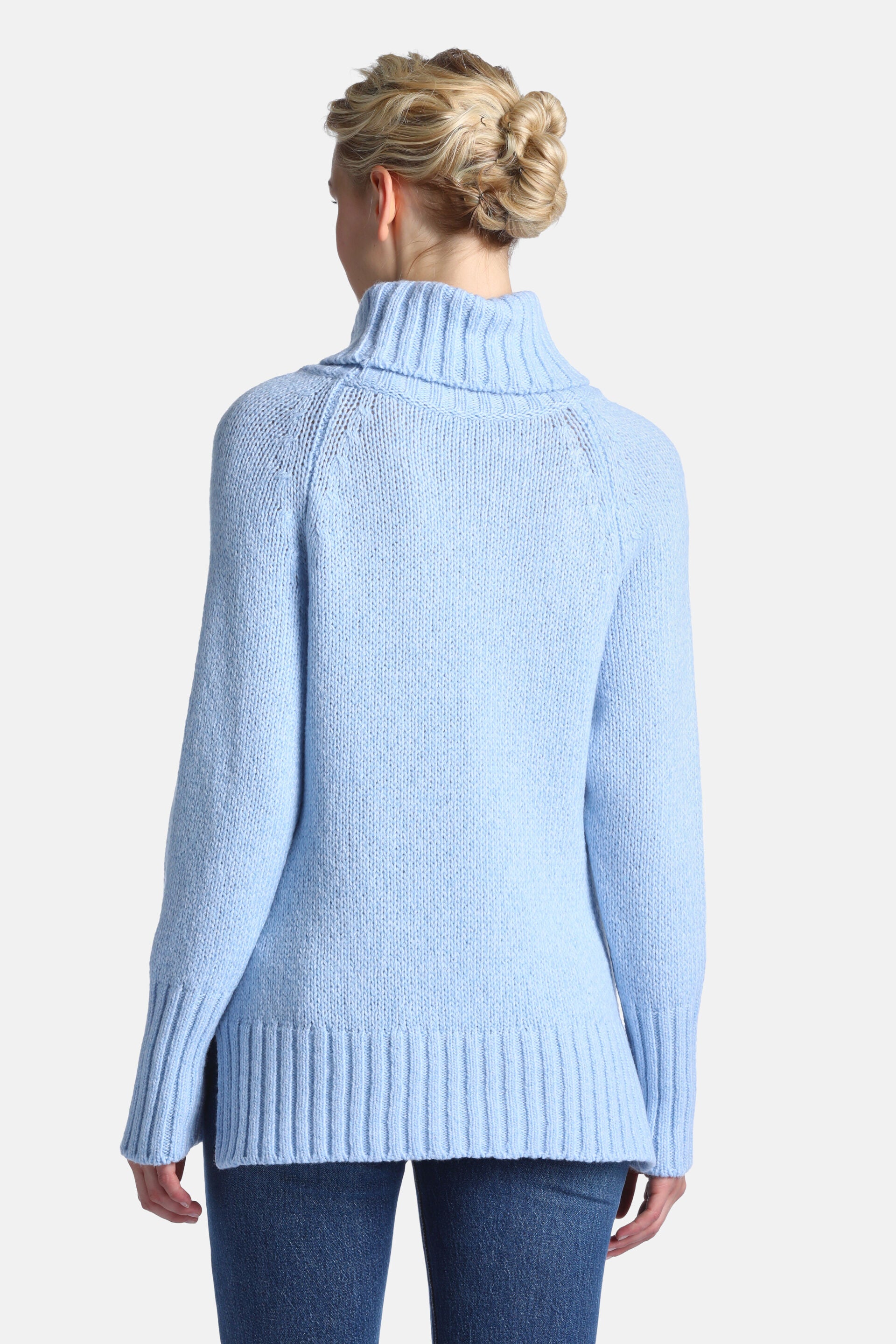 Light blue sweater with a cowl neck, long raglan sleeves, ribbed cuffs, and a ribbed hem with side slits.