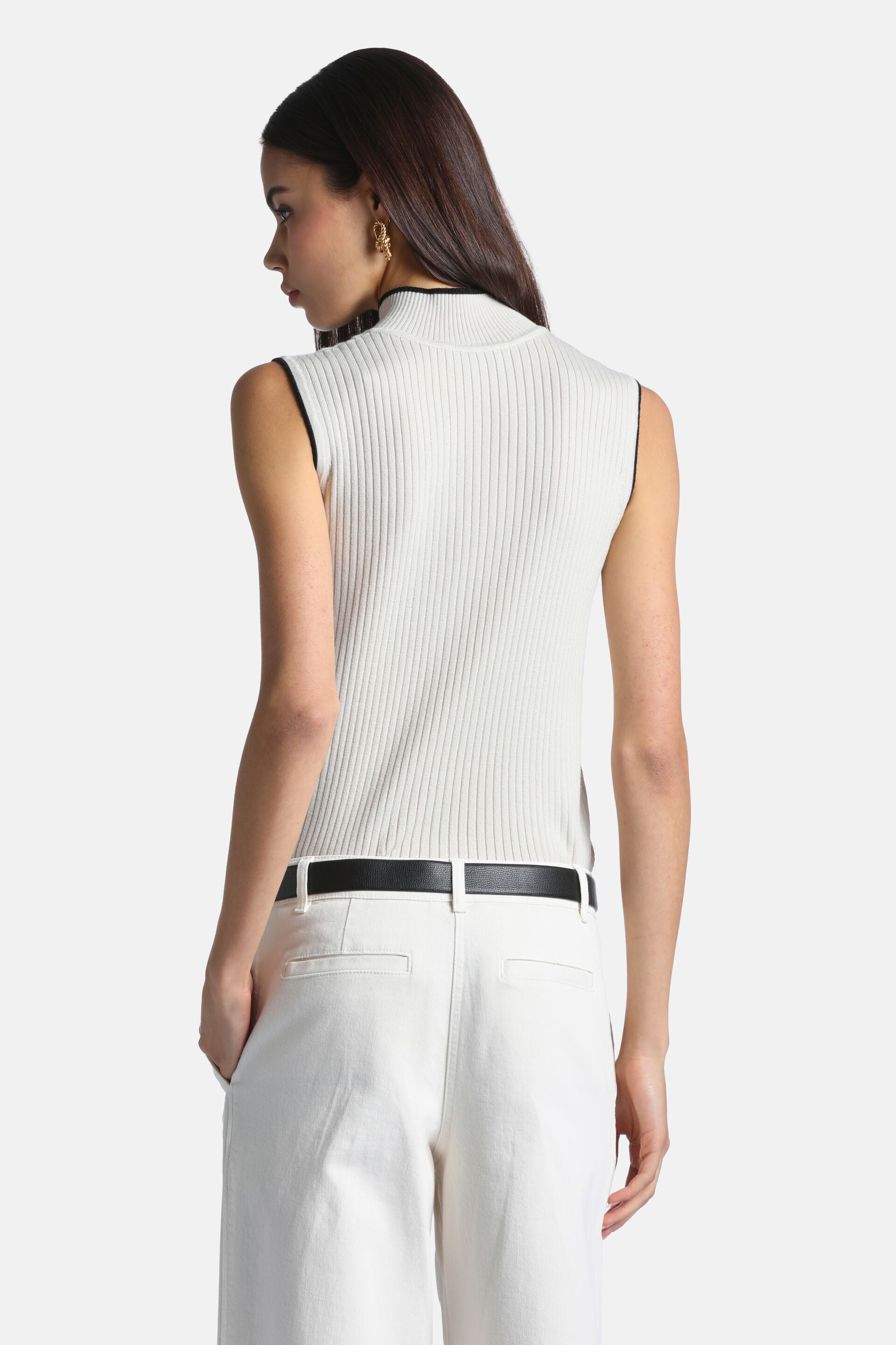 Cream ribbed knit sleeveless top with a mock neck, featuring black trim along the neckline and armholes.
