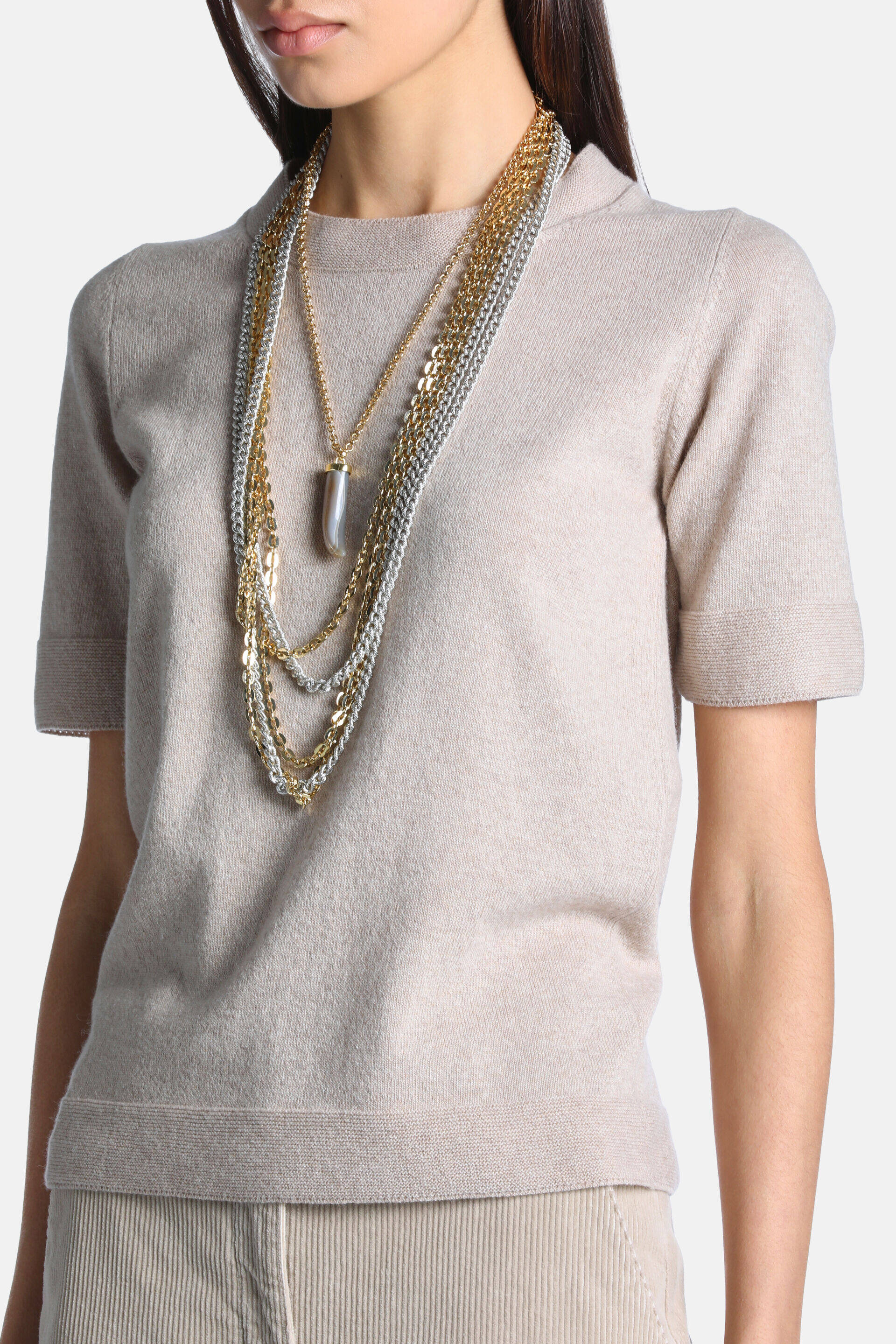 Beige short-sleeved pullover with a mock neck, fine knit texture, and ribbed cuffs and hem.