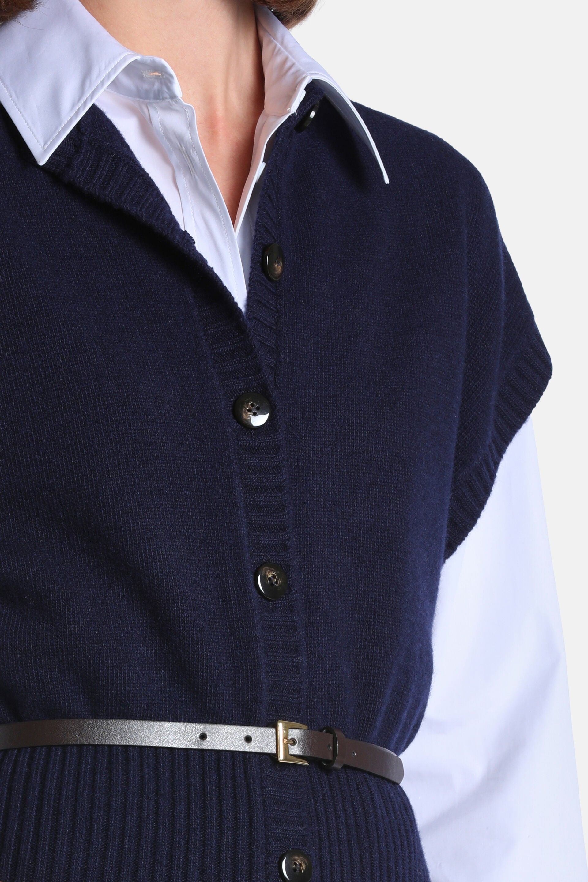 Navy blue knitted waistcoat with a V-neck, button-front closure, ribbed trim, and a thin dark brown belt with a gold-toned bu