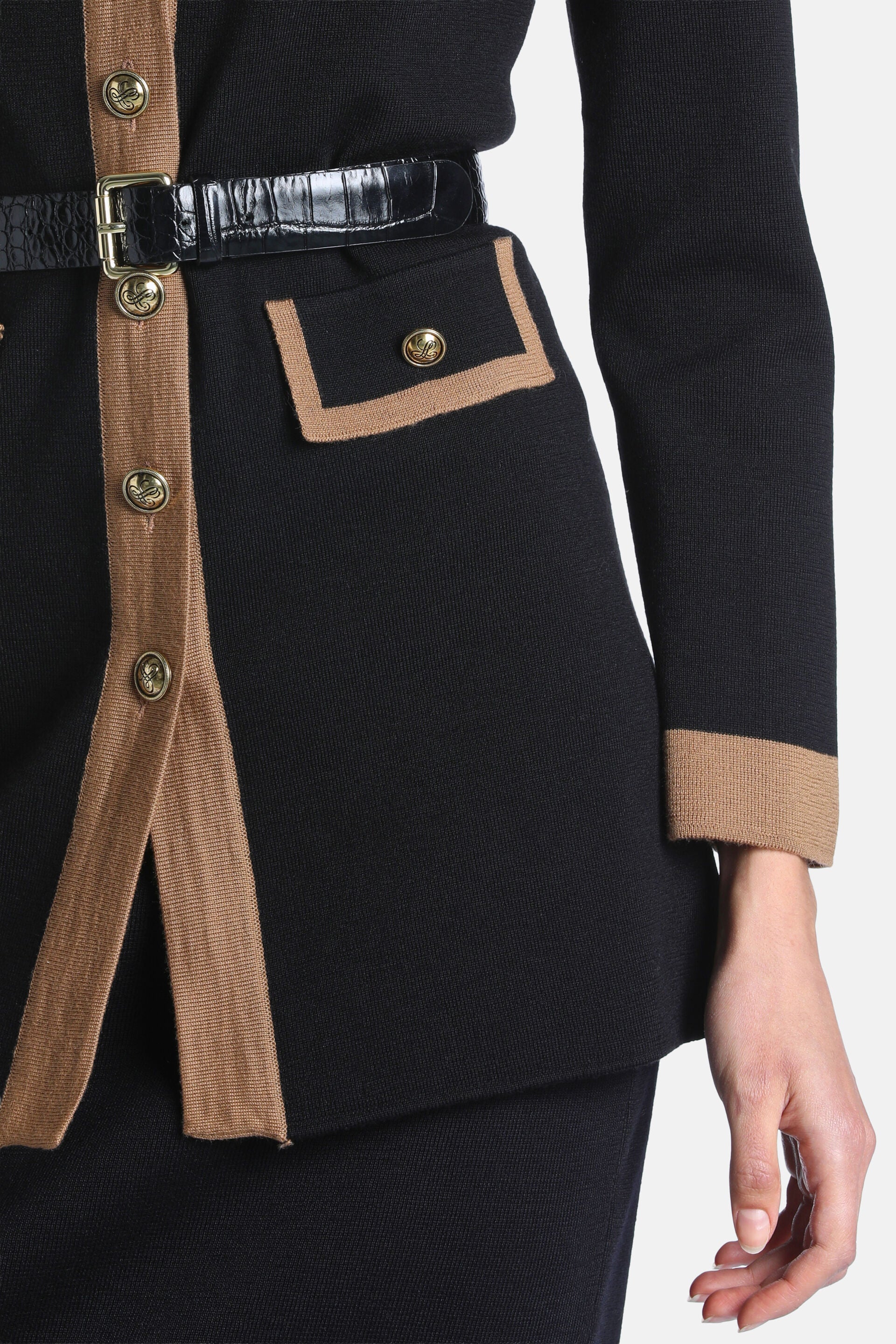 Black knit cardigan with camel trim on placket, cuffs, and pocket. Gold-toned buttons and a black crocodile-embossed belt.