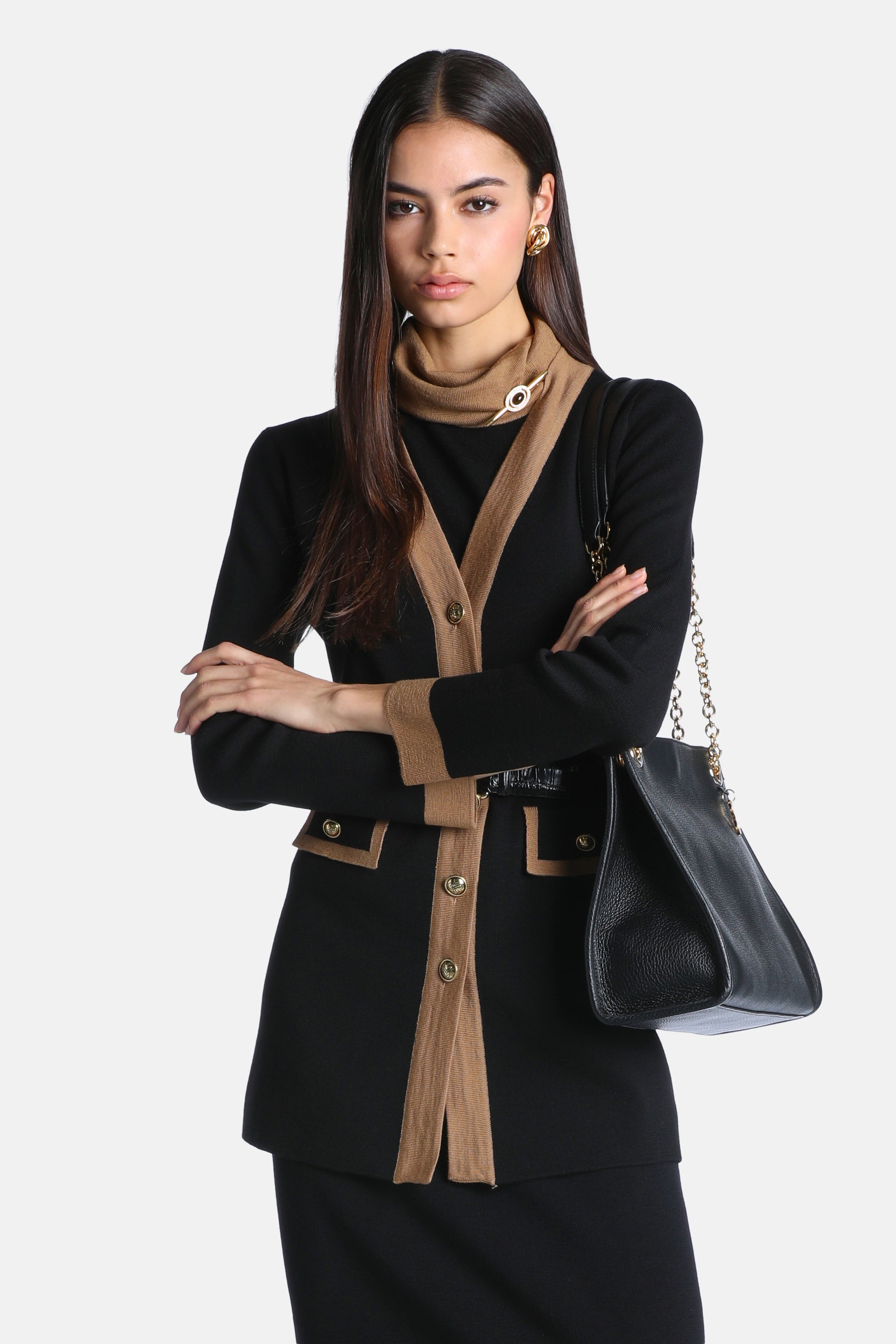 Black long-sleeved cardigan with camel-colored trim along the V-neck opening, placket, cuffs, and two pocket flaps. Features