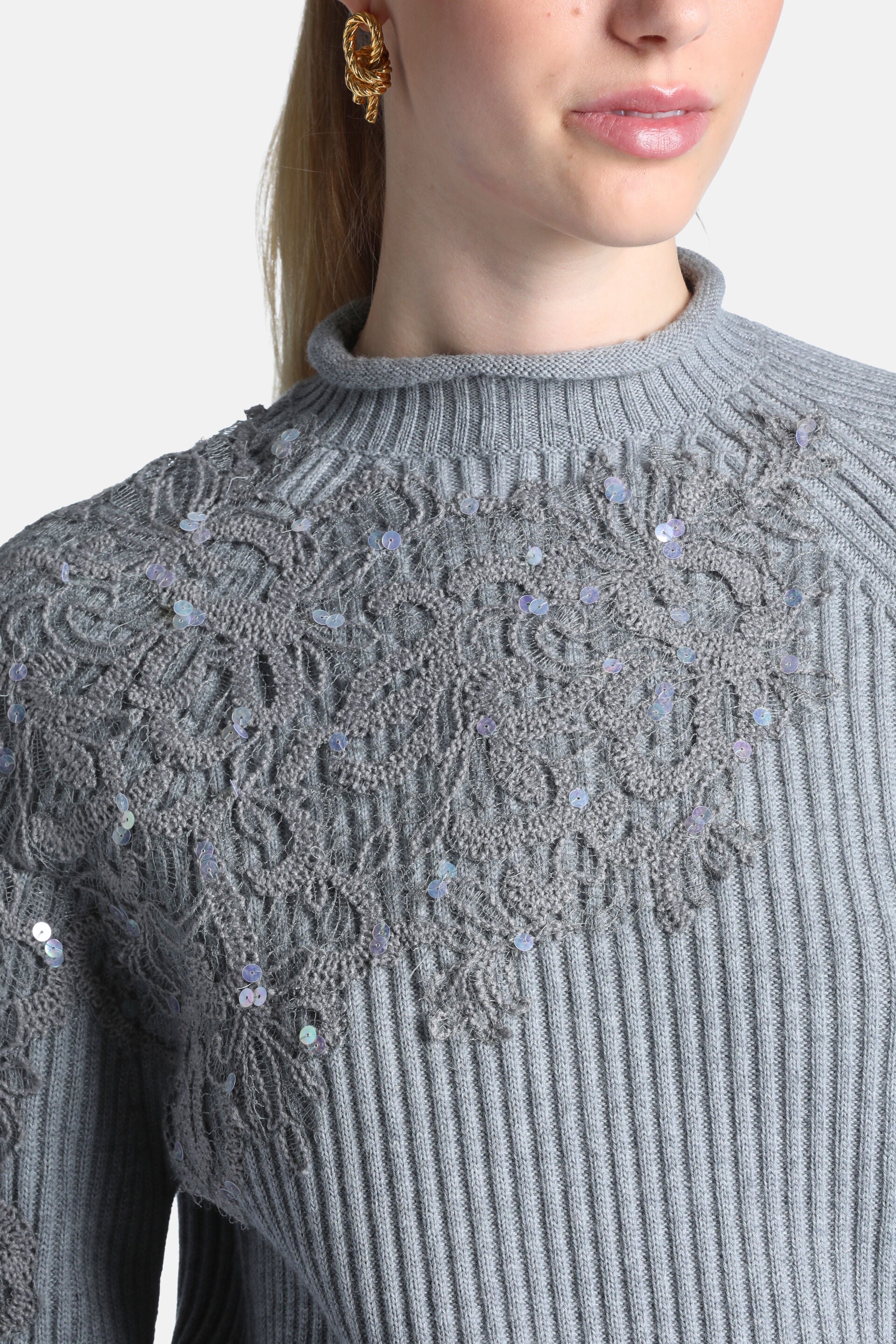 Grey melange ribbed knit pullover with a mock neck and an open-knit floral pattern on the yoke, embellished with iridescent s