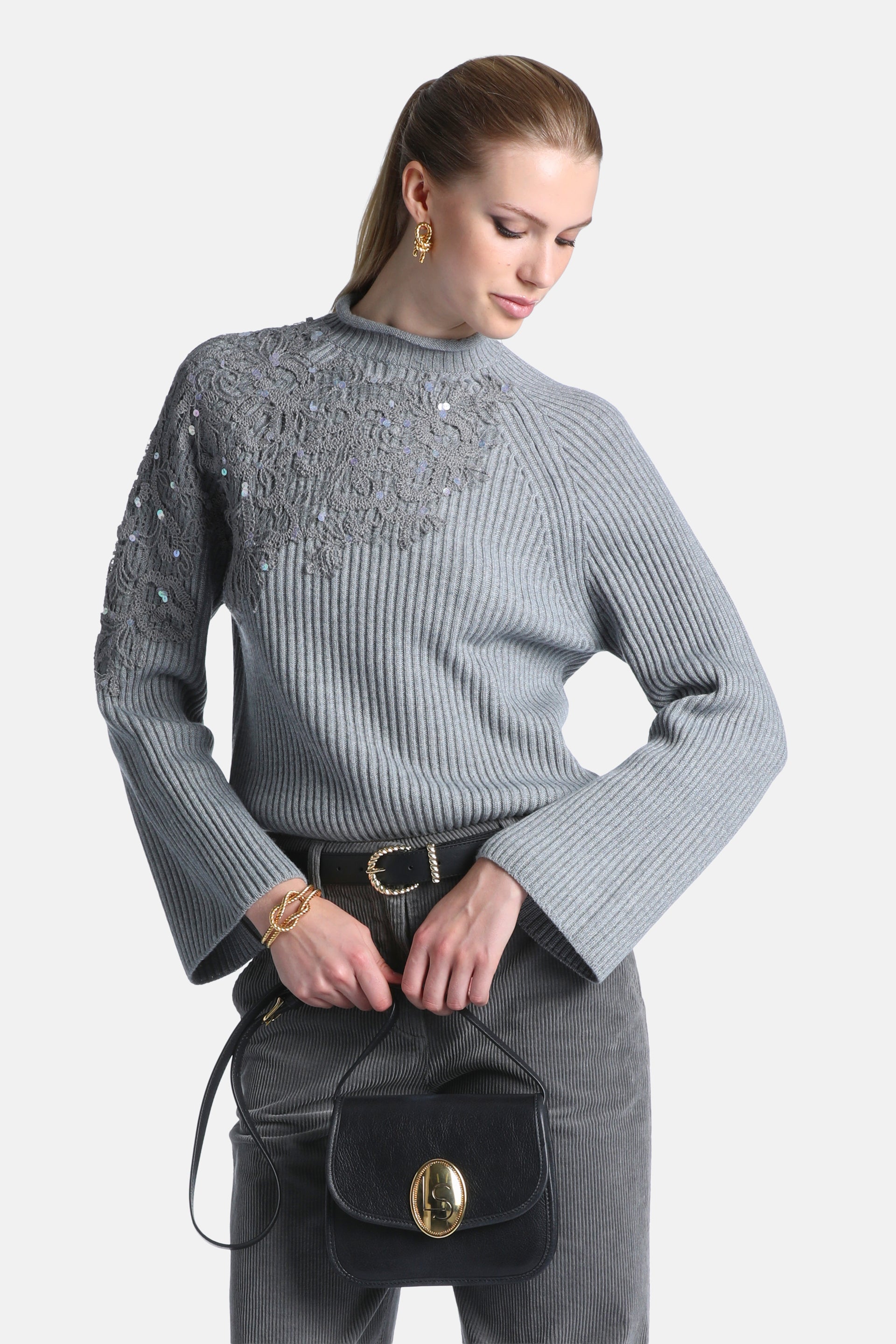 Grey melange ribbed knit pullover with a mock neck. Features an intricate crochet and sequin pattern on the upper chest and l
