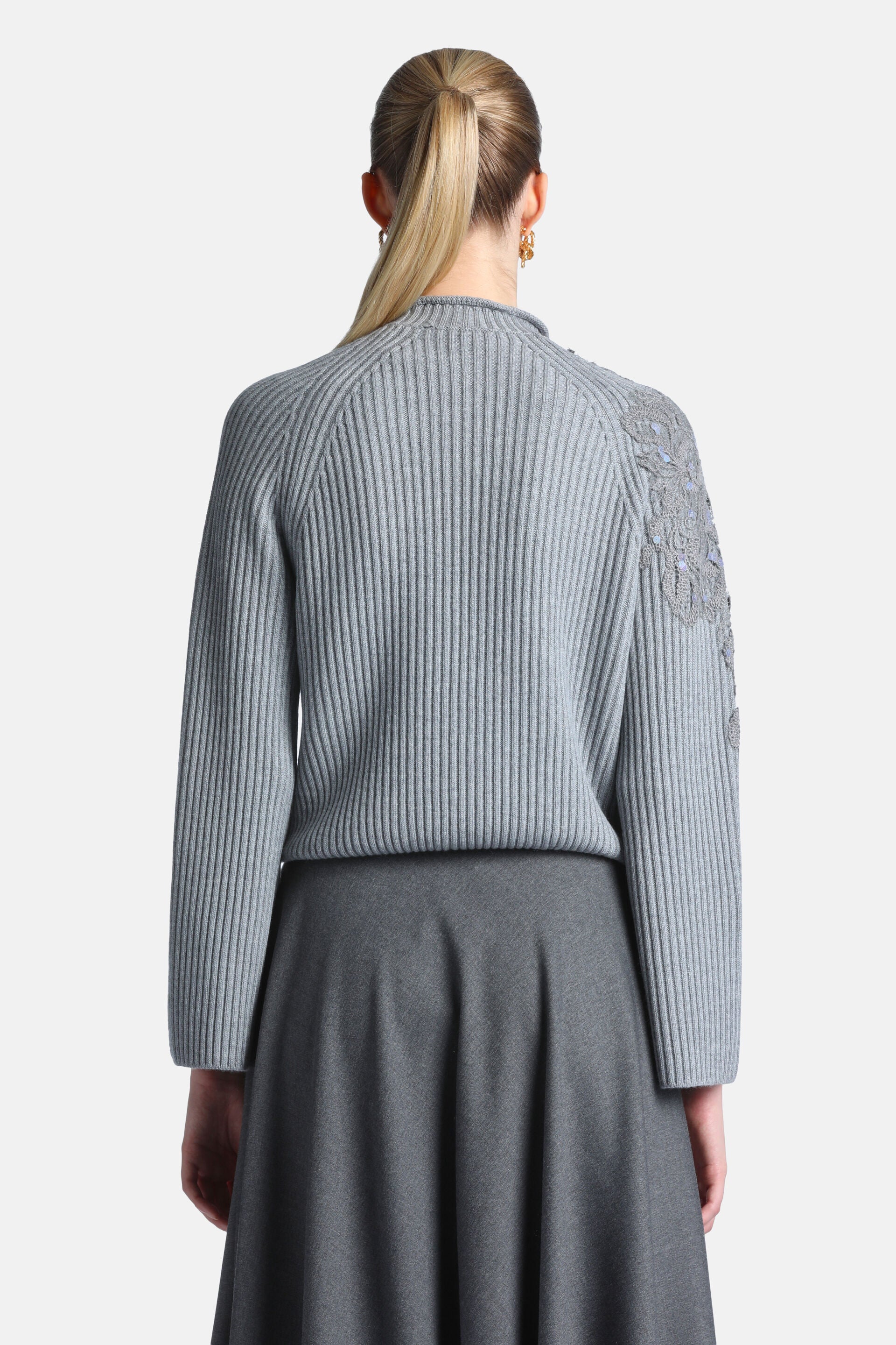 Grey melange ribbed knit pullover with a high neck, long raglan sleeves, and a floral embroidered design on the left shoulder