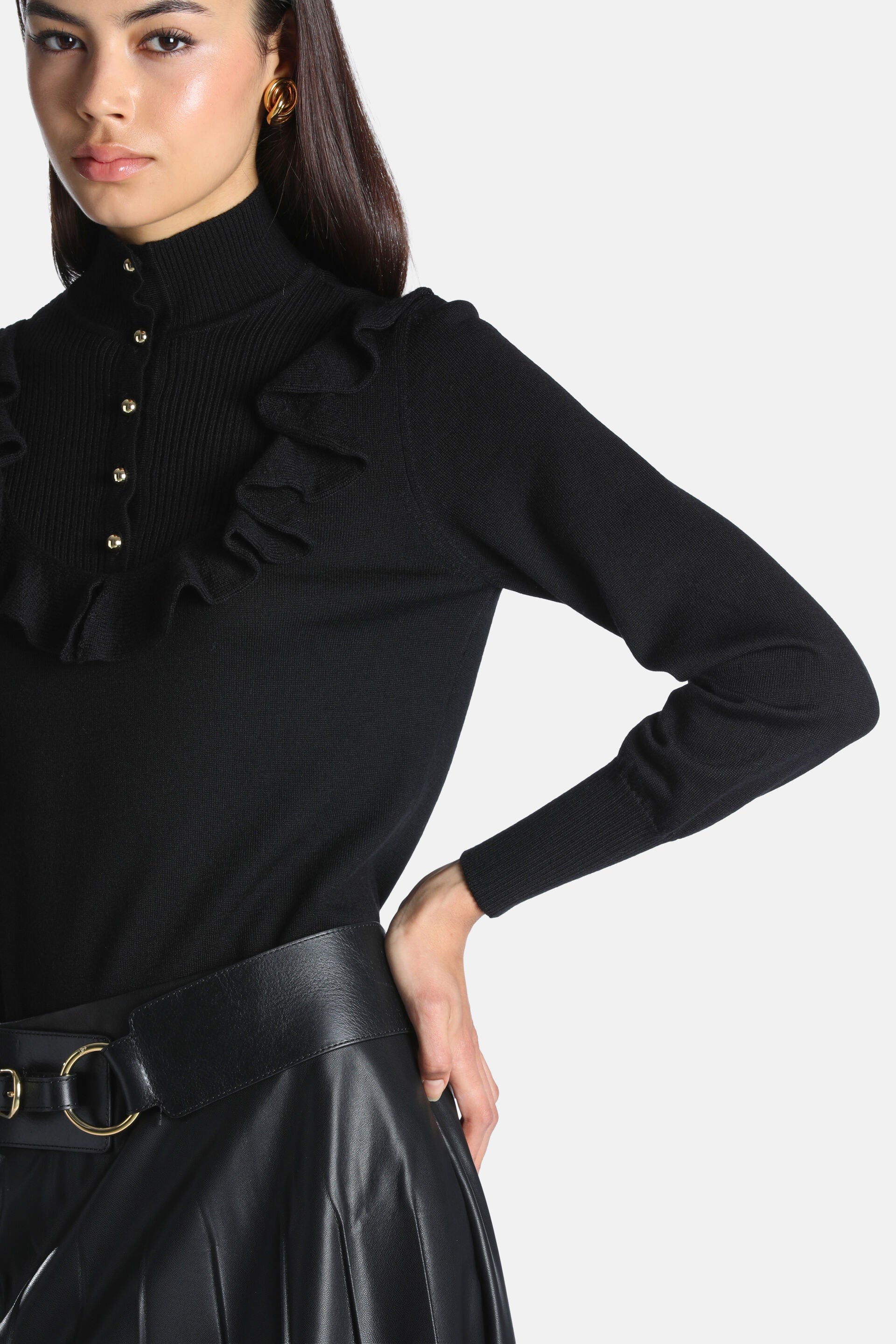 Black high-neck pullover with a ribbed front panel, five gold-toned buttons, and ruffled trim down the chest. Long sleeves wi