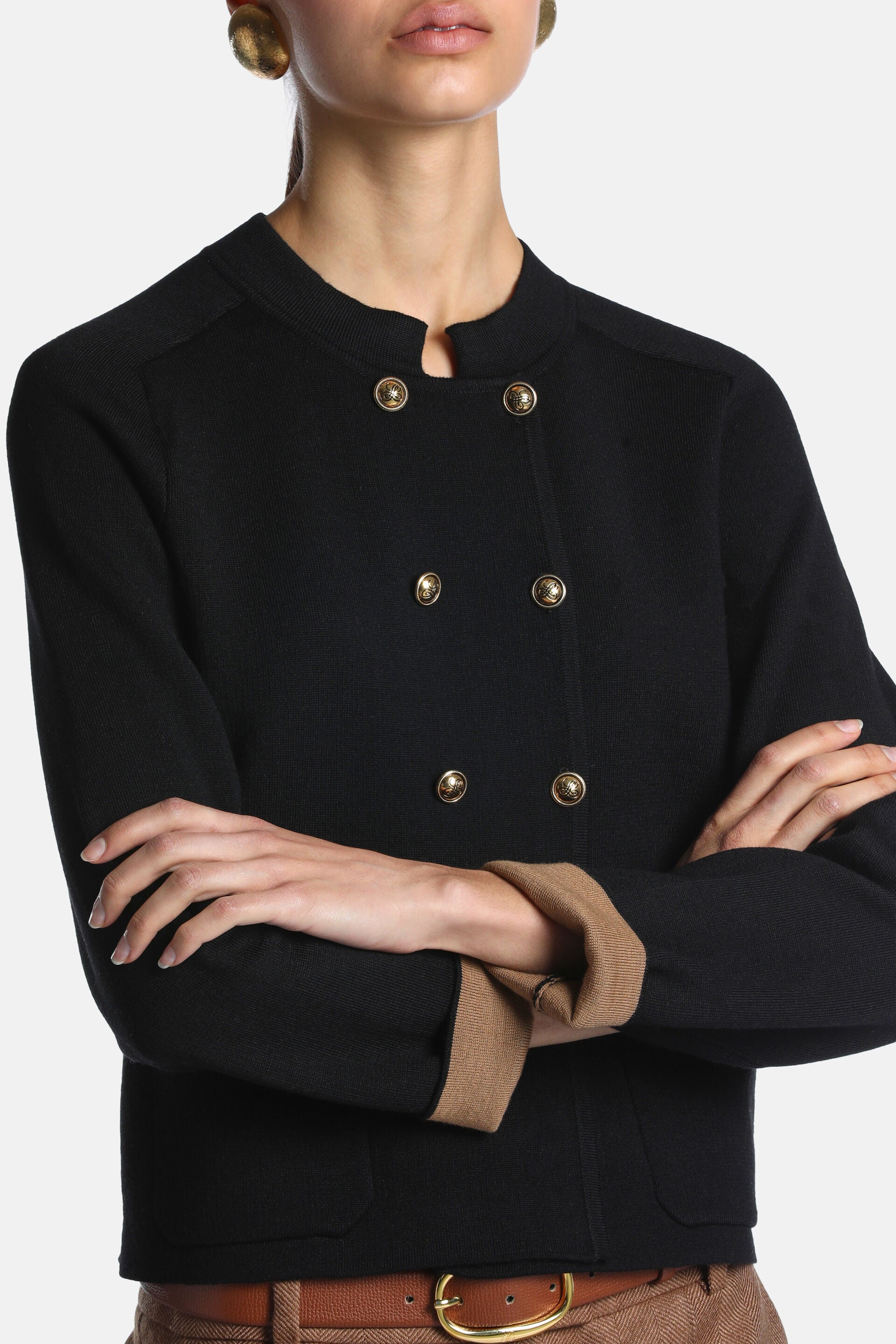Black wool jacket with a collarless V-notch neck, double-breasted front with six ornate gold-toned buttons, and a tan-lined r