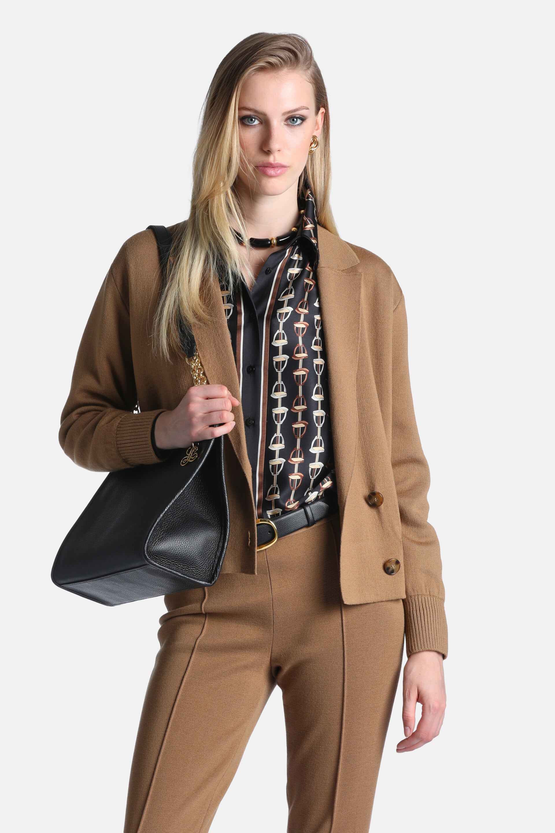 Camel knit jacket with notched lapels, long sleeves with ribbed cuffs, ribbed hem, and two brown buttons.