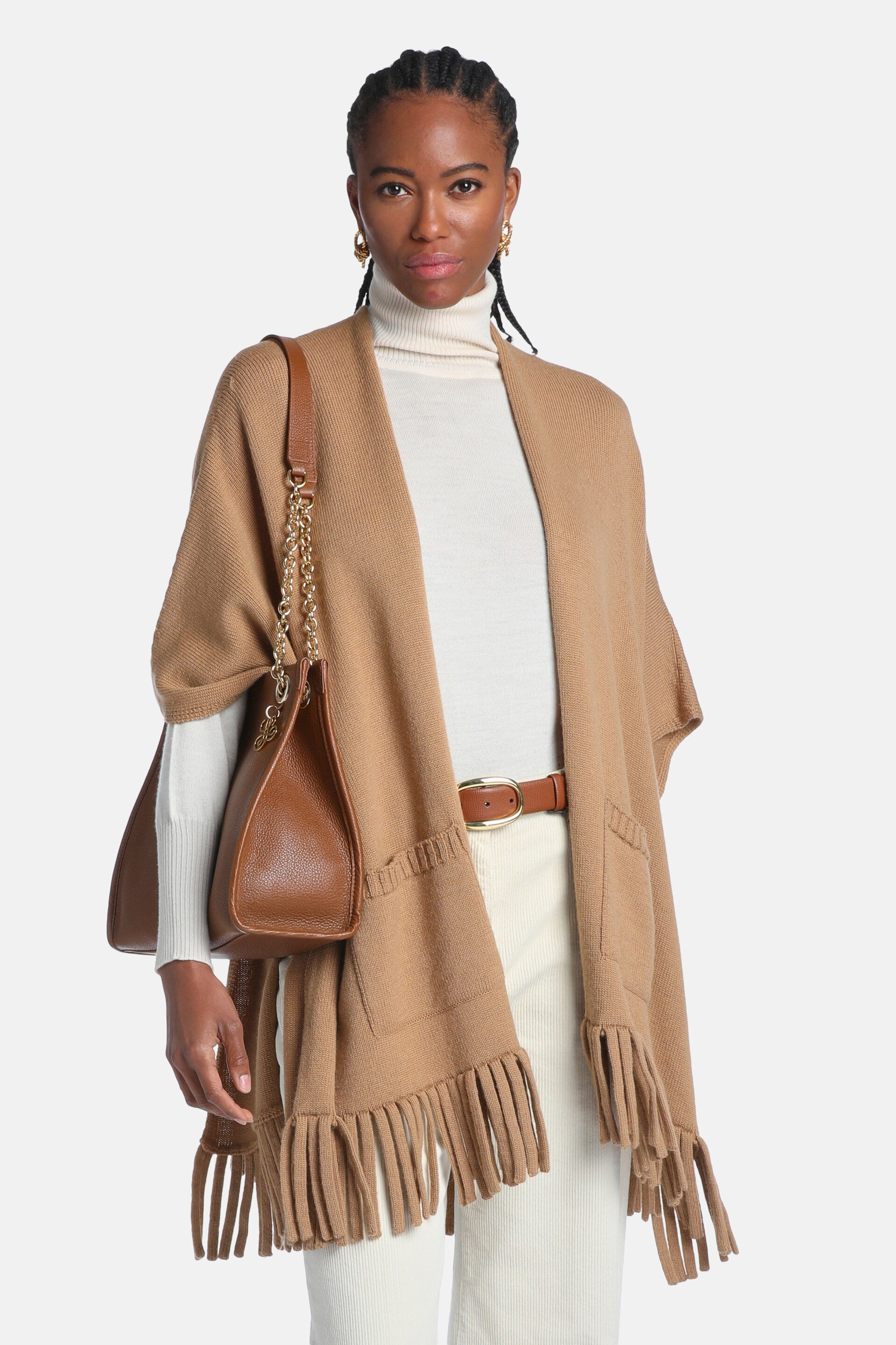 Camel knit open-front mantle with two front patch pockets and a fringed hem.