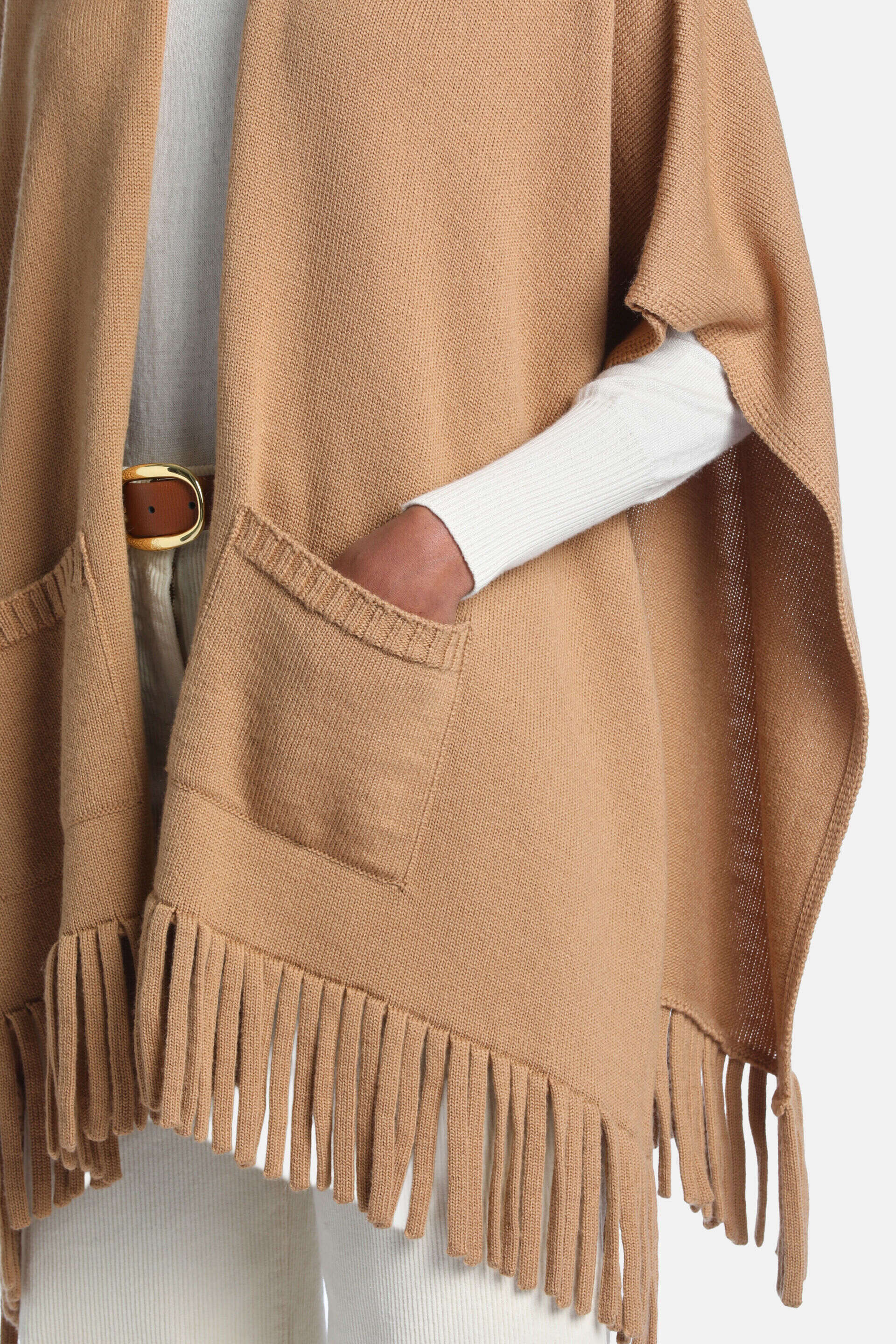 Tan knitted mantle with two front patch pockets and a fringed hem.