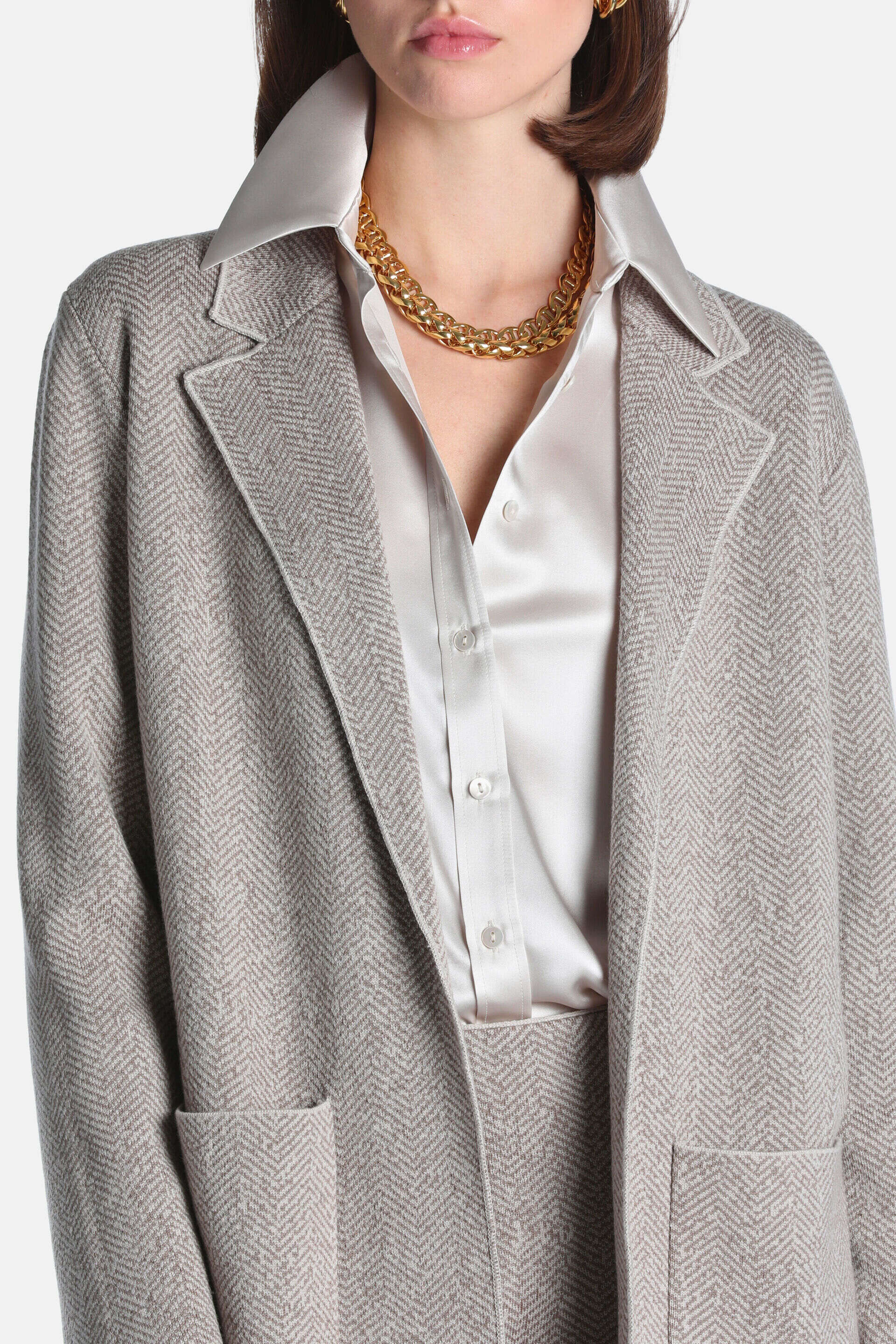 Beige herringbone jacket with notched lapels and two front patch pockets.