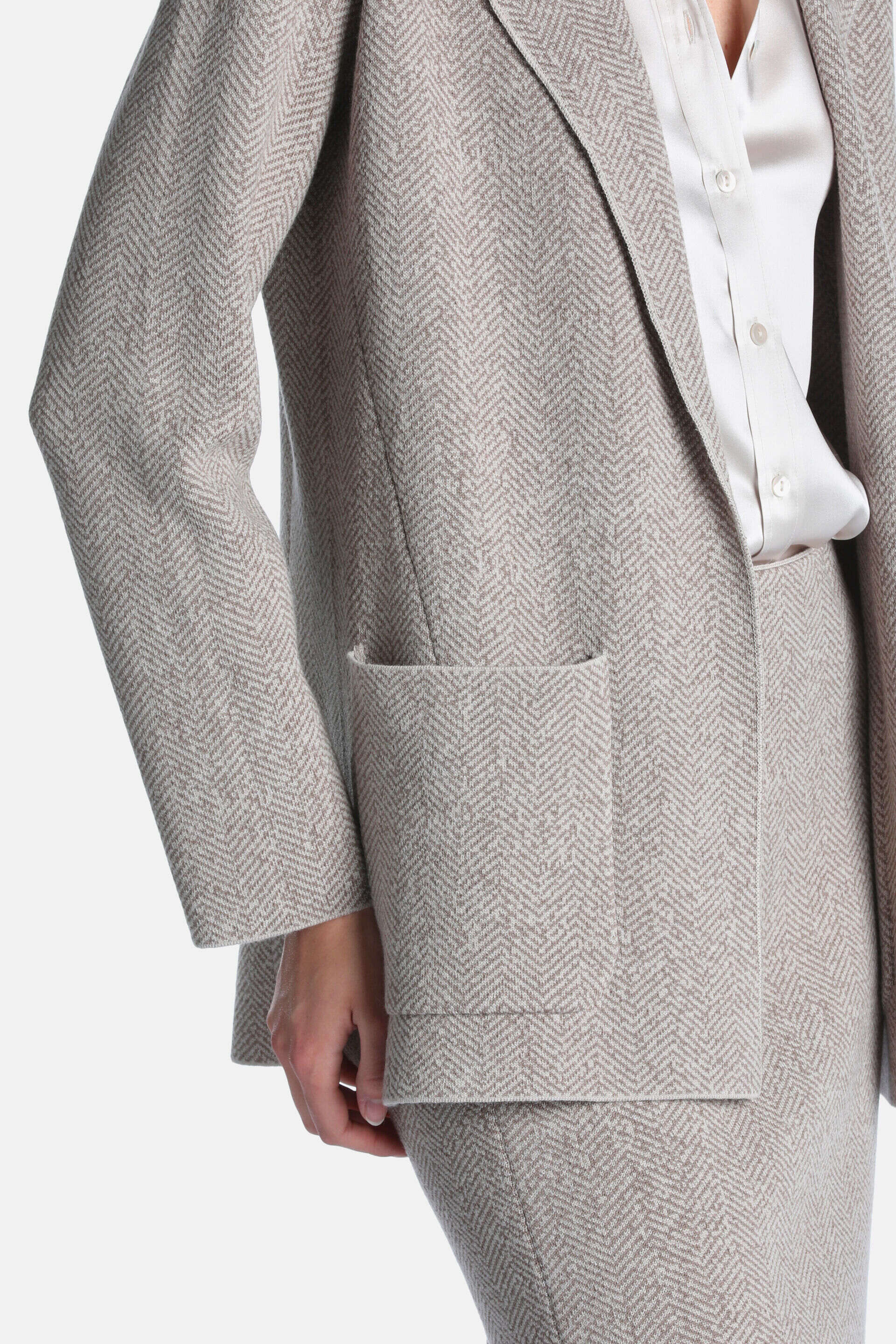 Beige herringbone blazer jacket with lapel, long sleeves, and a front patch pocket.