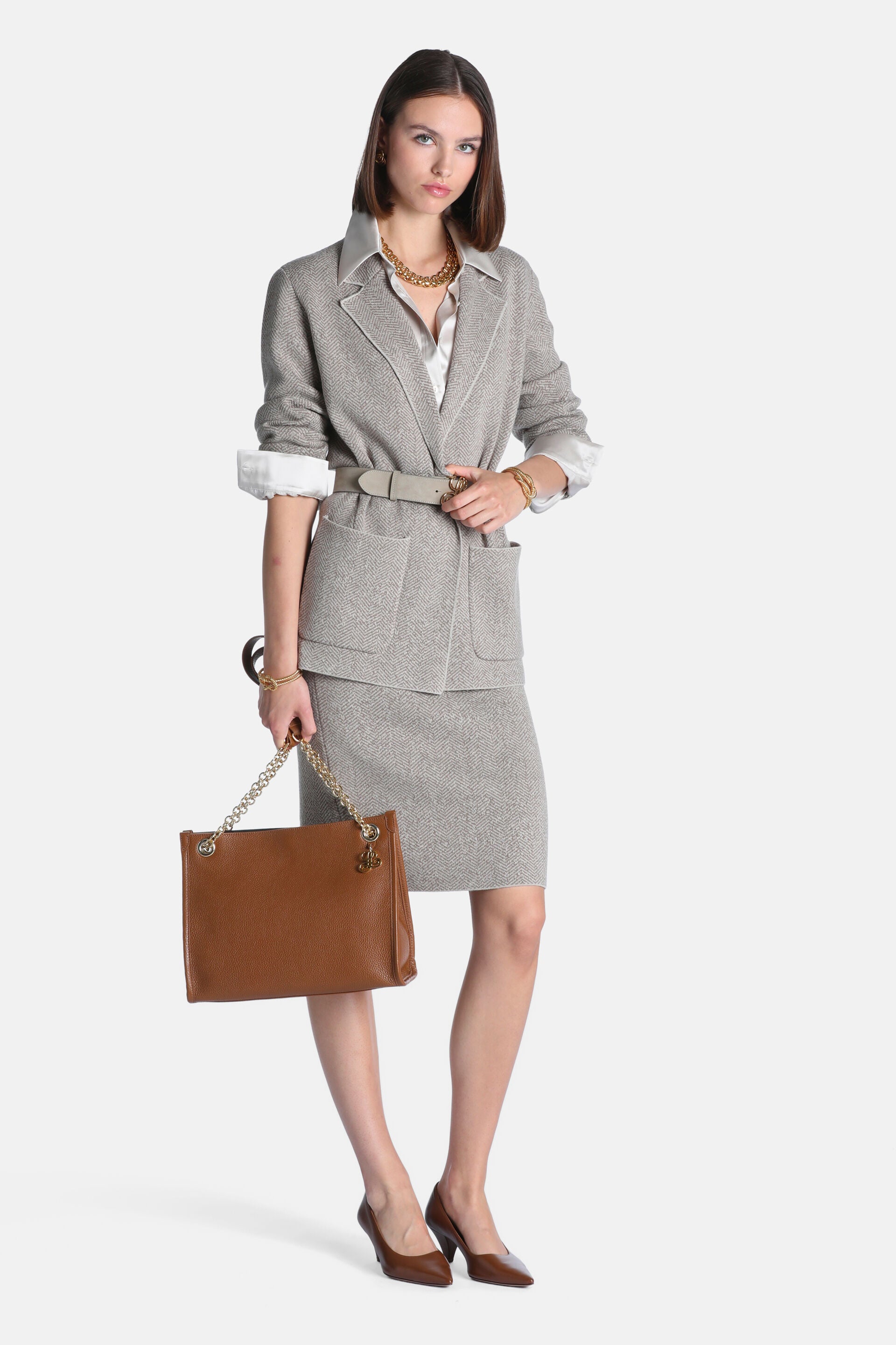 Beige herringbone open-front jacket with lapel collar, white trim along lapels and front, and two large front patch pockets.