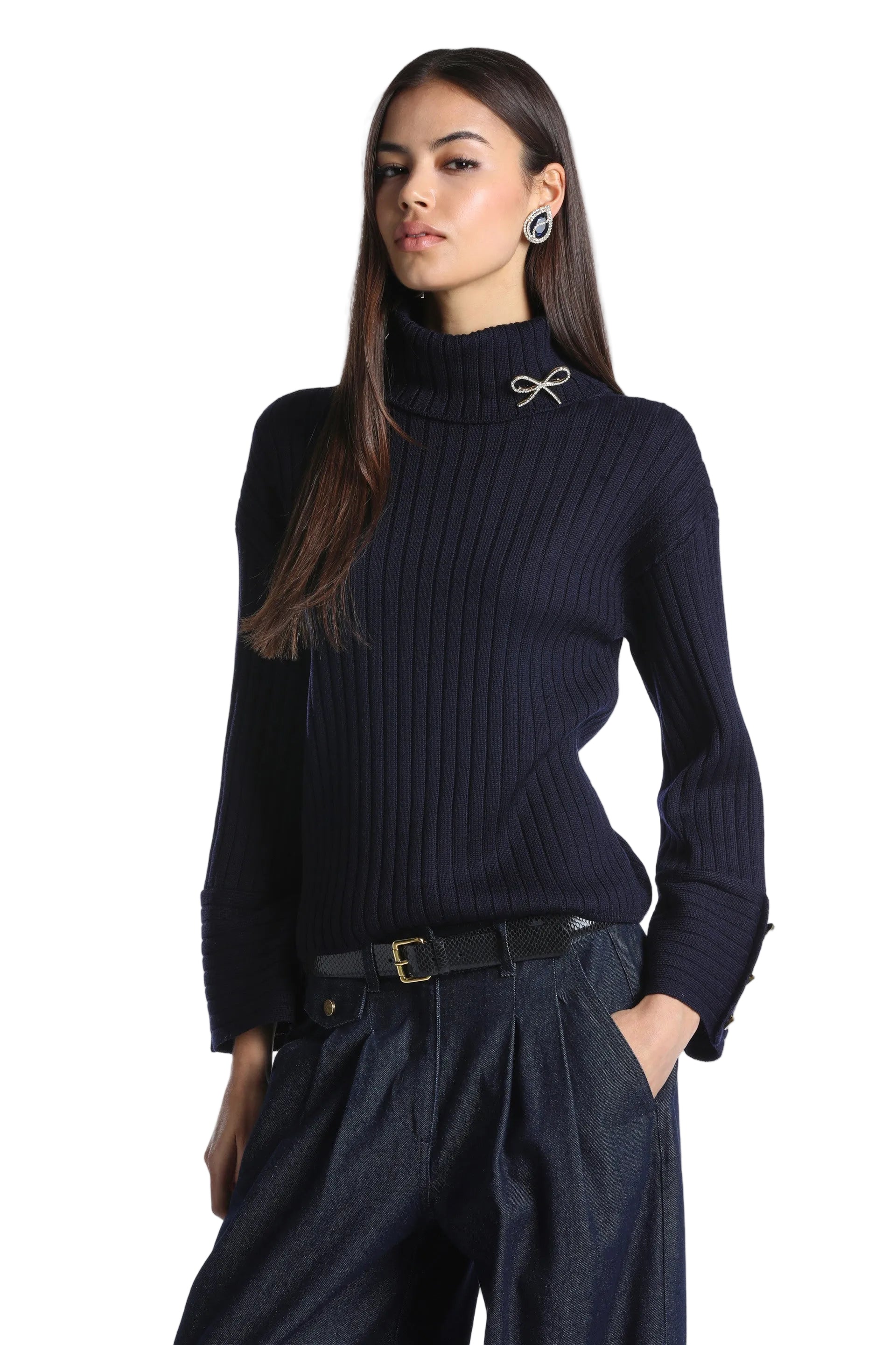 Dark blue ribbed knit turtleneck pullover with long sleeves, folded cuffs with gold-toned buttons, and a gold-toned bow.