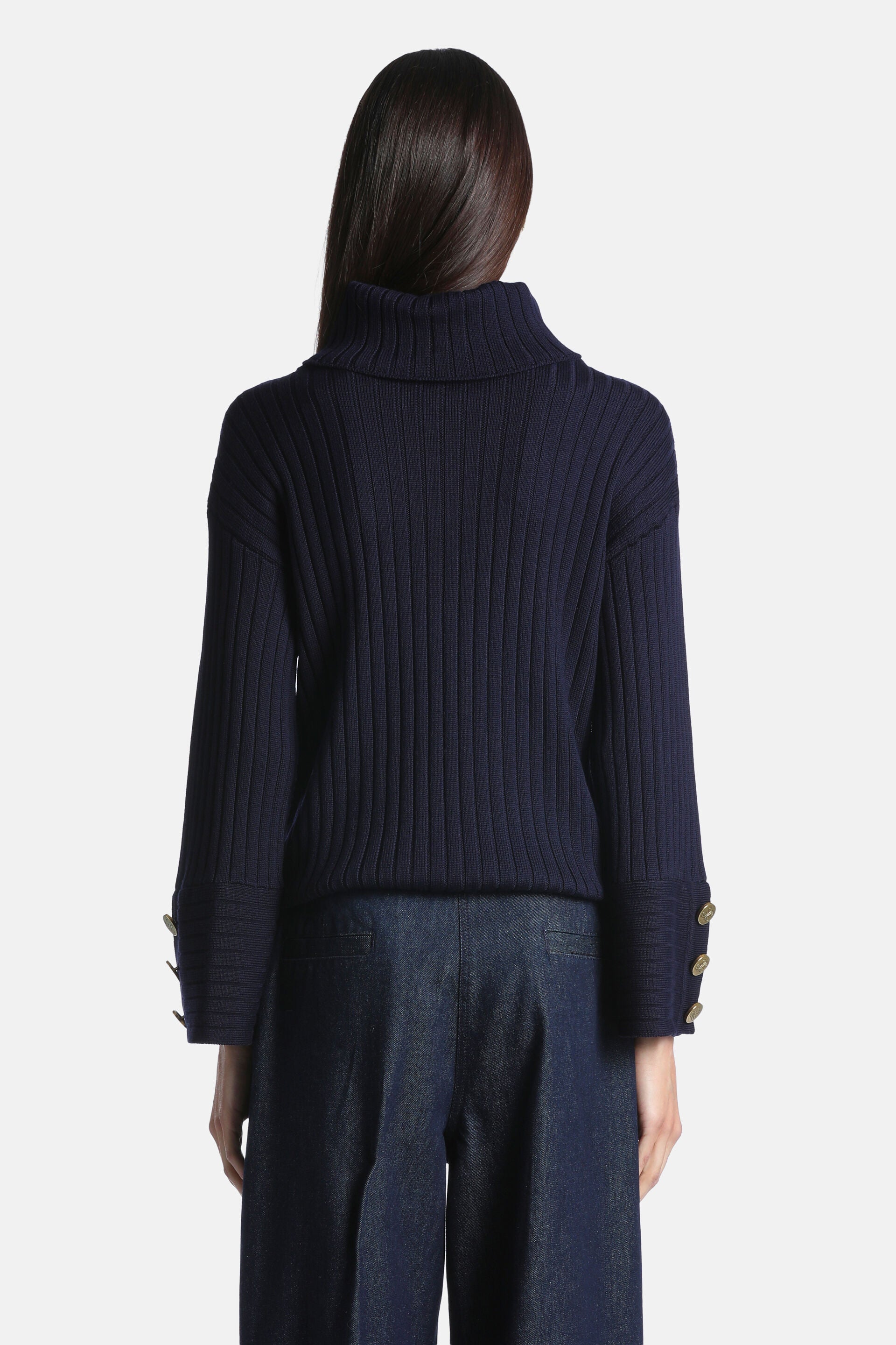 Navy blue ribbed knit turtleneck pullover with long sleeves and wide cuffs, each featuring three gold-toned buttons.