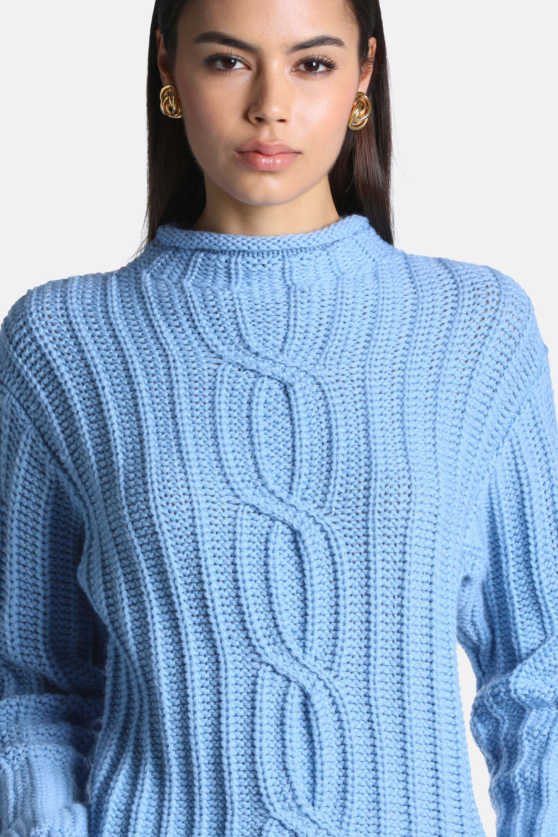 Light blue chunky knit pullover with a mock neck and a central cable knit design flanked by vertical ribbing.