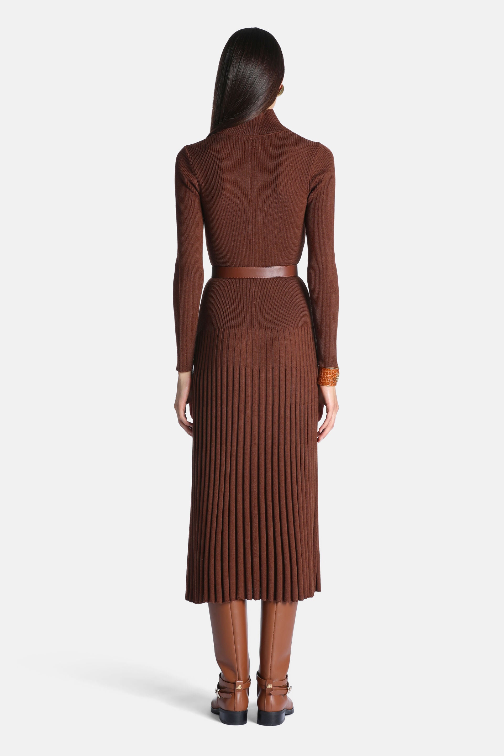 Brown ribbed knit dress with a turtleneck, long sleeves, and a pleated midi skirt, cinched with a thin brown belt.