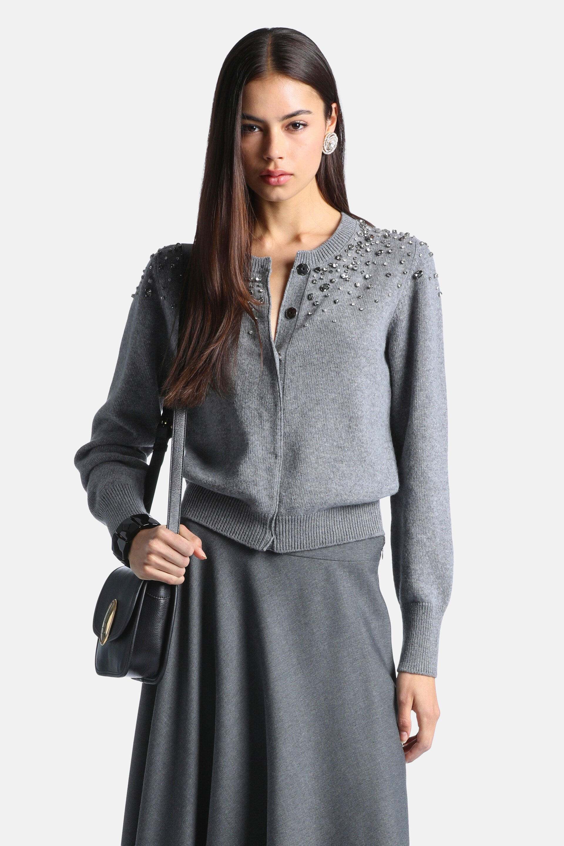 Grey knitted cardigan with a round neck, button front, and silver-toned stud embellishments on shoulders and upper chest. Rib