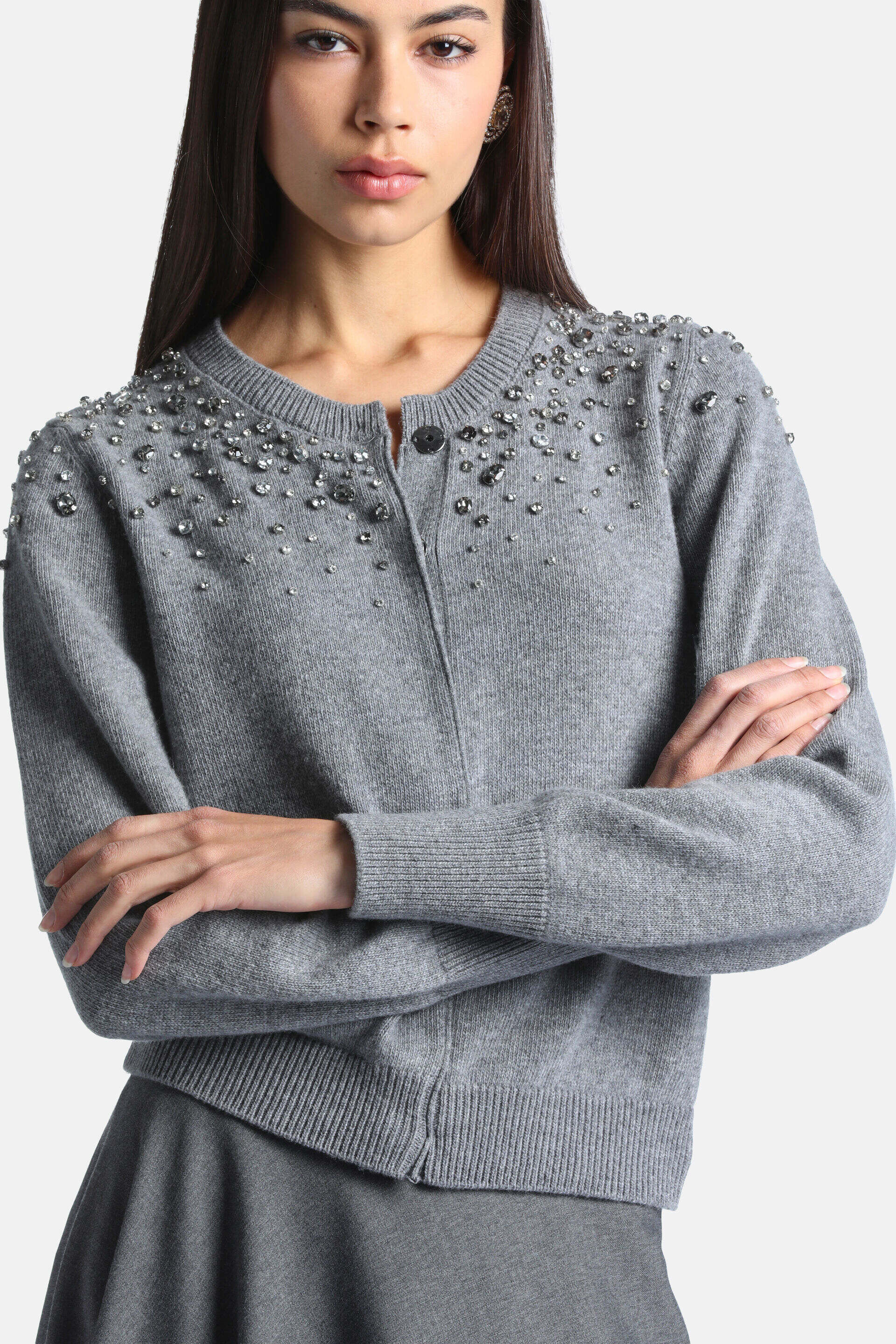 Grey knit cardigan with silver-toned embellishments on shoulders and chest. Ribbed cuffs, hem, and front button closure.