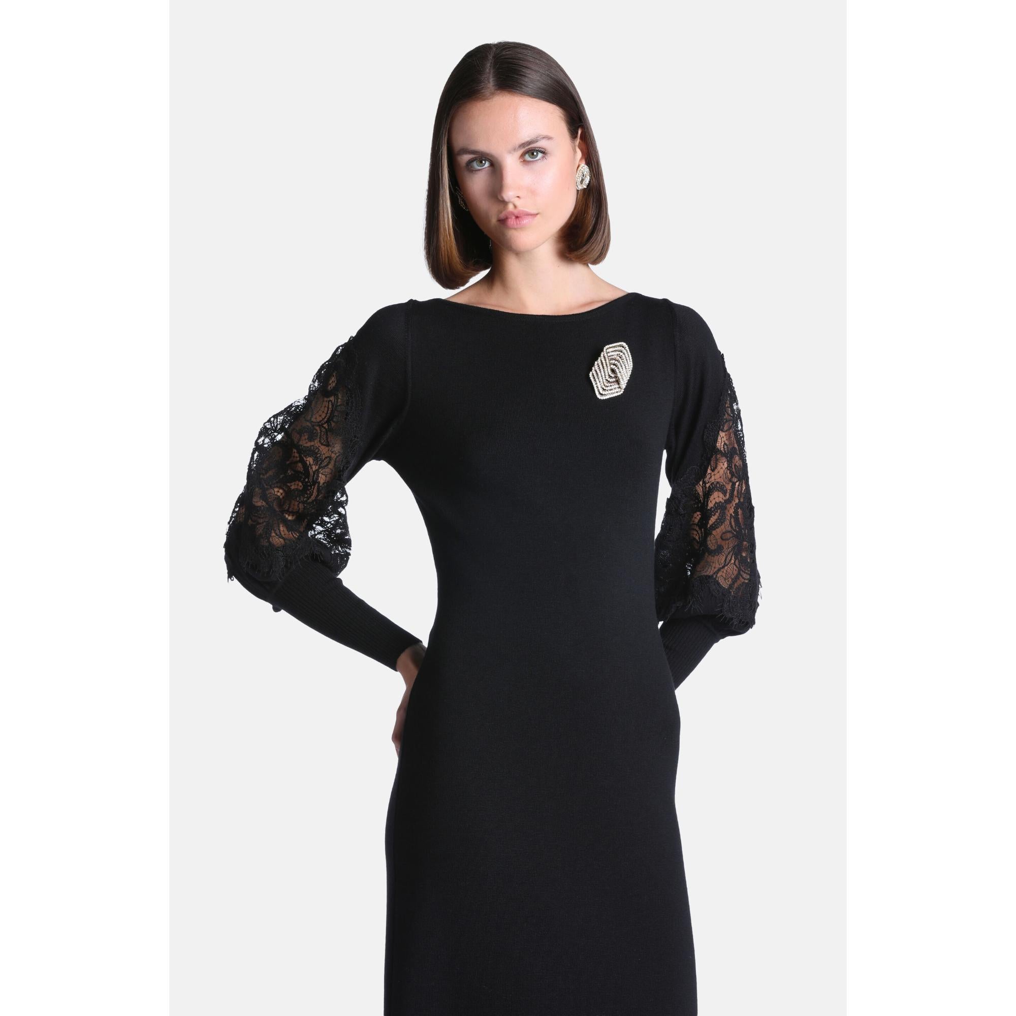 Black knit dress with a boat neck and long sleeves. The lower sleeves are black floral lace, gathered at ribbed cuffs. Featur