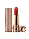 Open tube of matte red lipstick with a rose gold-toned casing and gold-toned inner tube, next to its matching cap.
