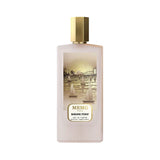Frosted light pink rectangular perfume bottle with a gold-toned cap and an illustrated label depicting a golden cityscape wit
